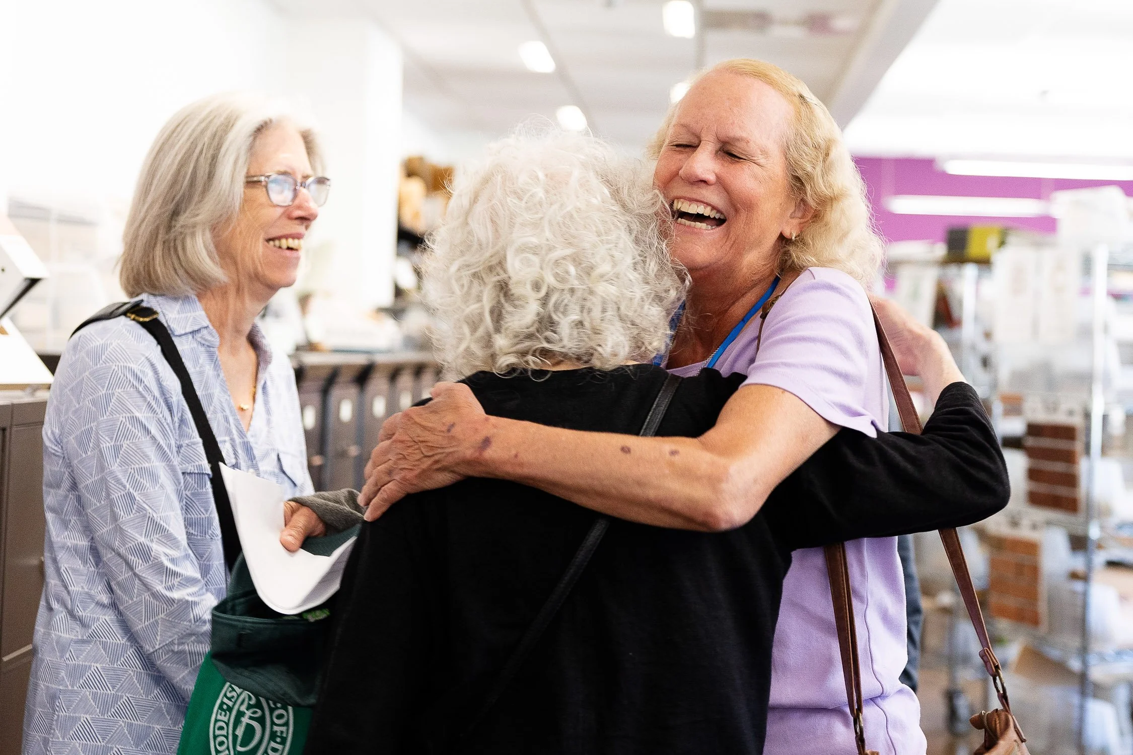 Three women happily hugging at their college reunion at RISD.