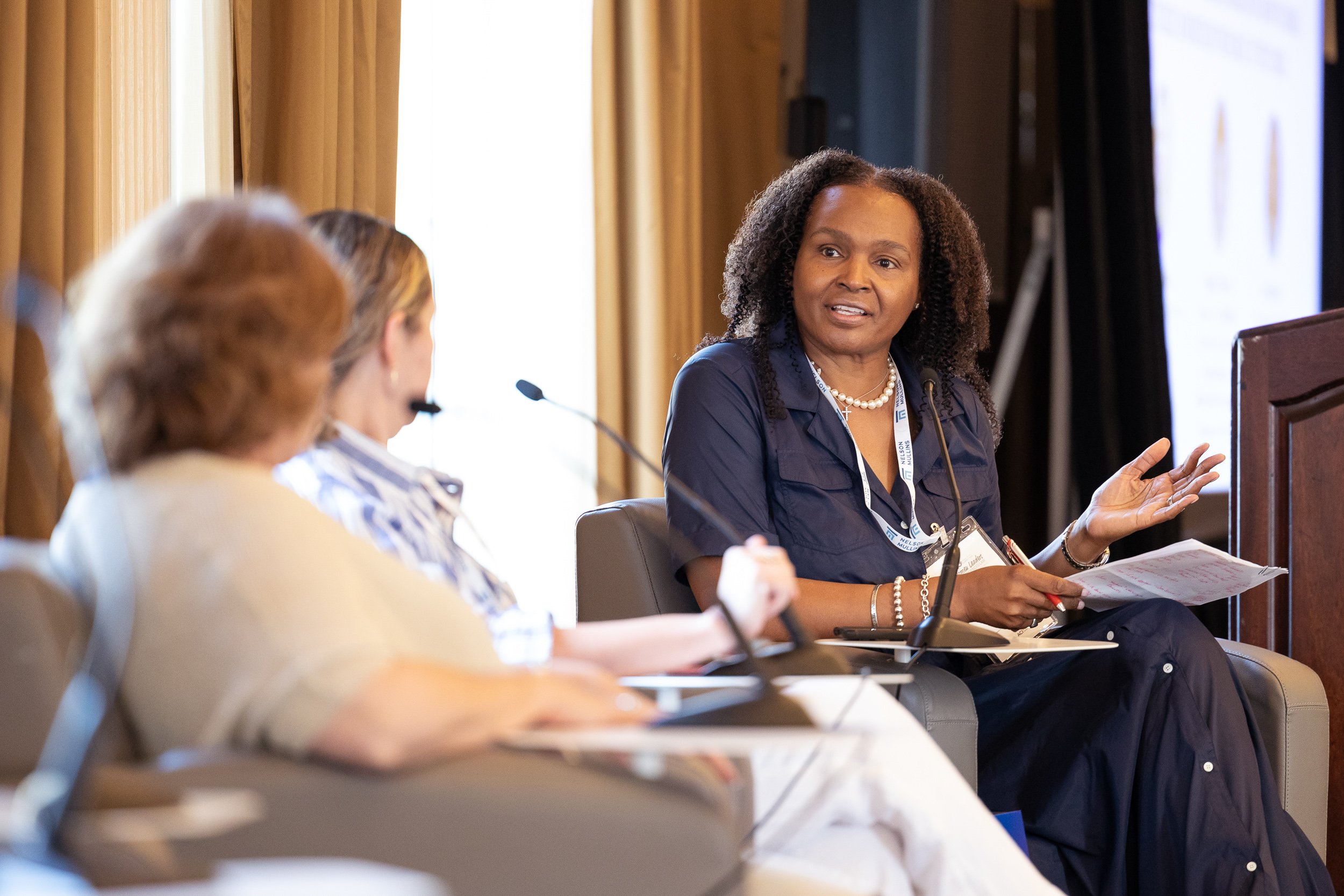 A woman speaking at a panel discussion during a biotech conference in Boston, Massachusetts.