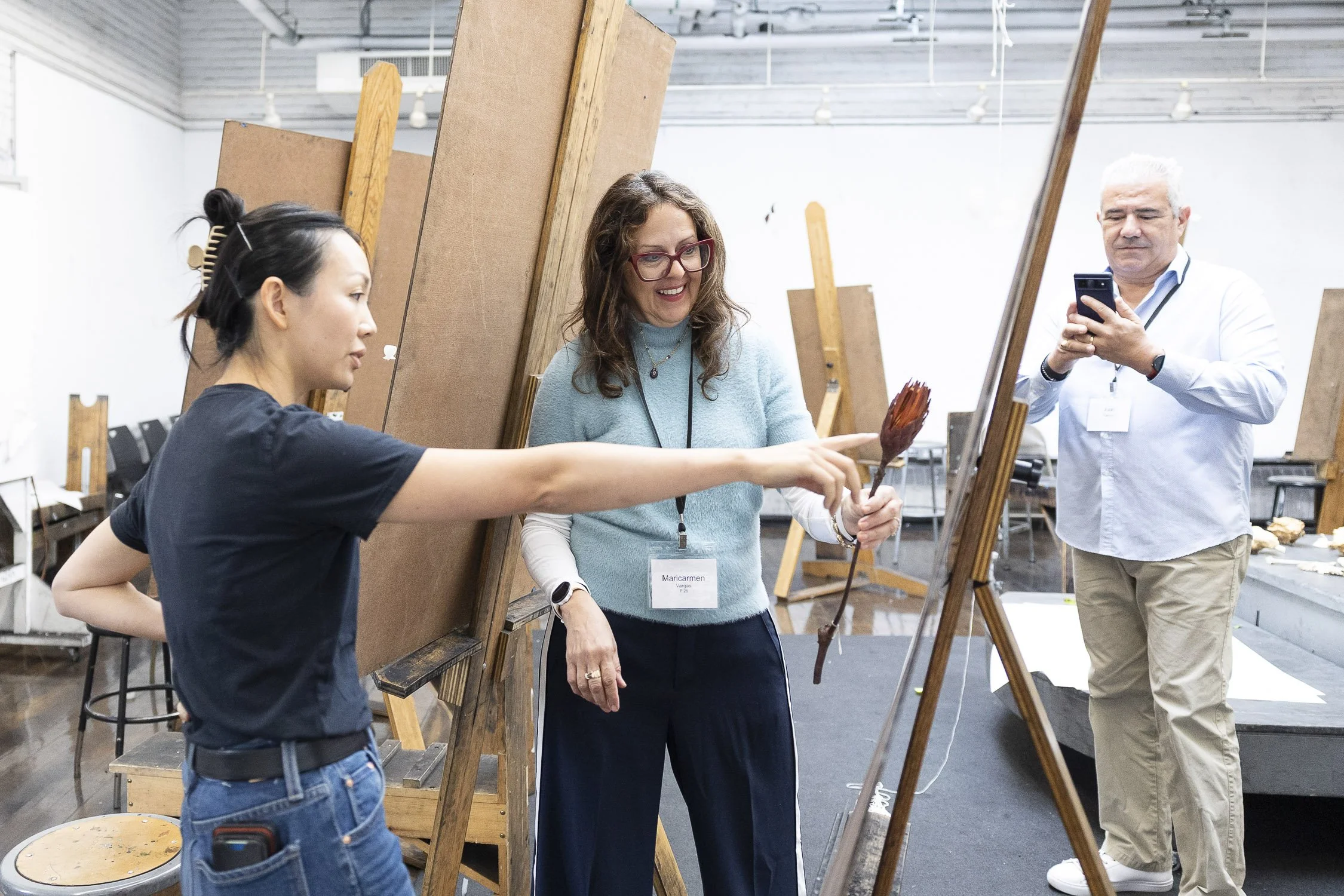 Instructor pointing to a student's easel in a drawing workshop in Boston.