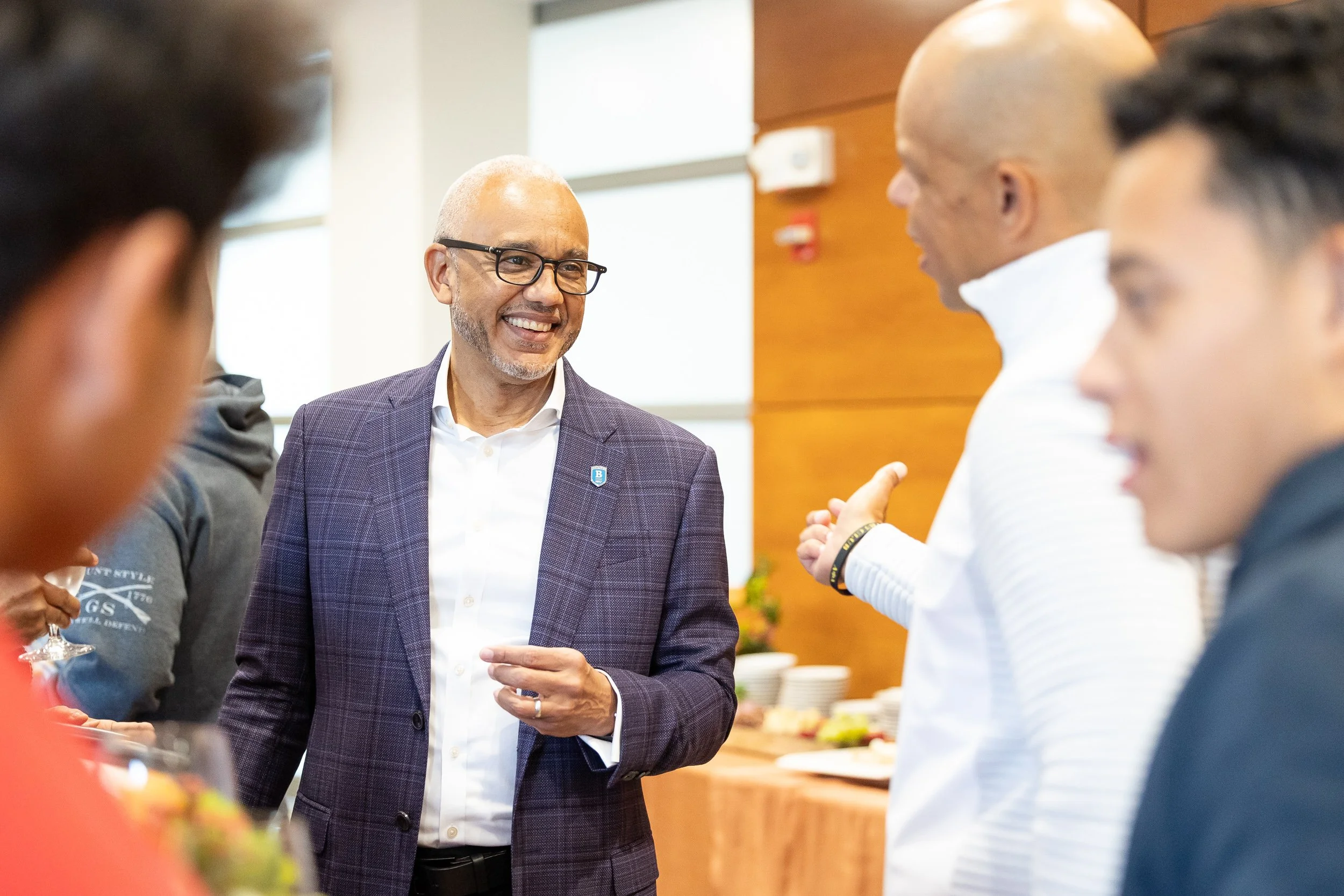 Bentley University president talking to a group of people at reunion.