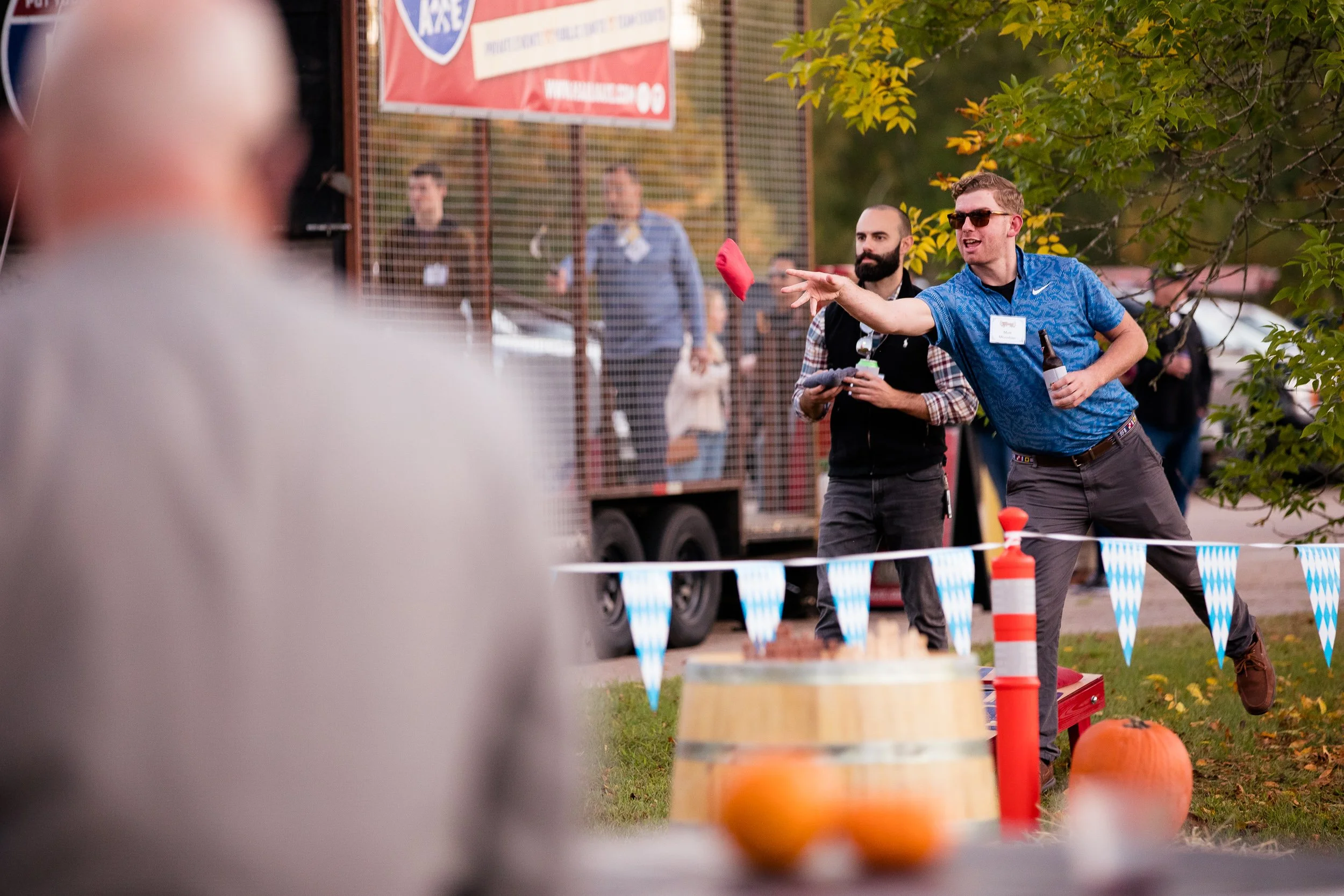 Two men playing outdoors at an event with autumn decorations in Boston.