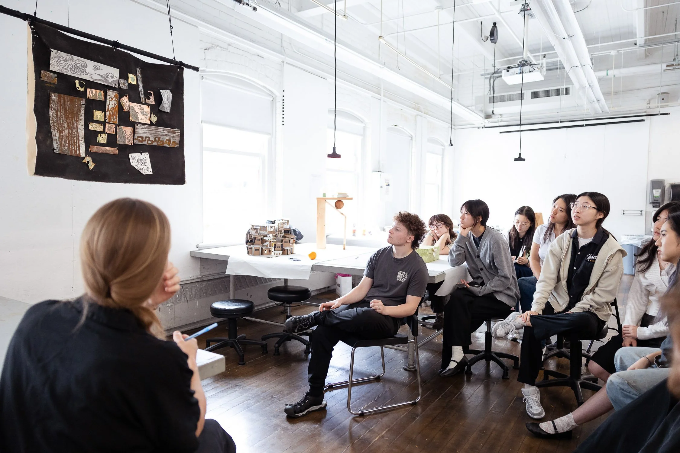 A group art students seated for critique at a Rhode Island art school.