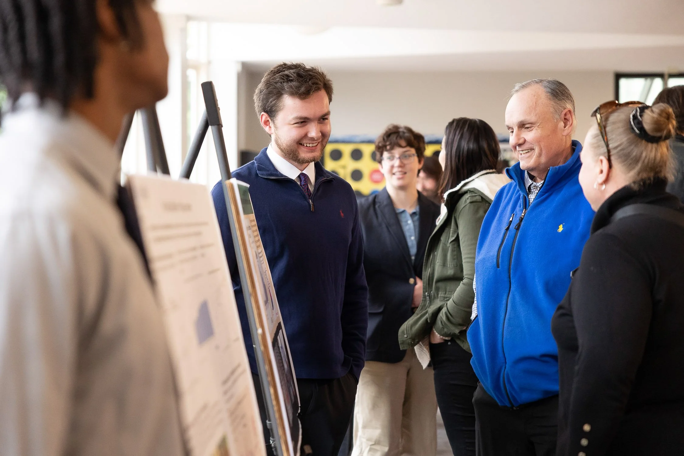 People talking at an indoor poster session at MassBay Community College.