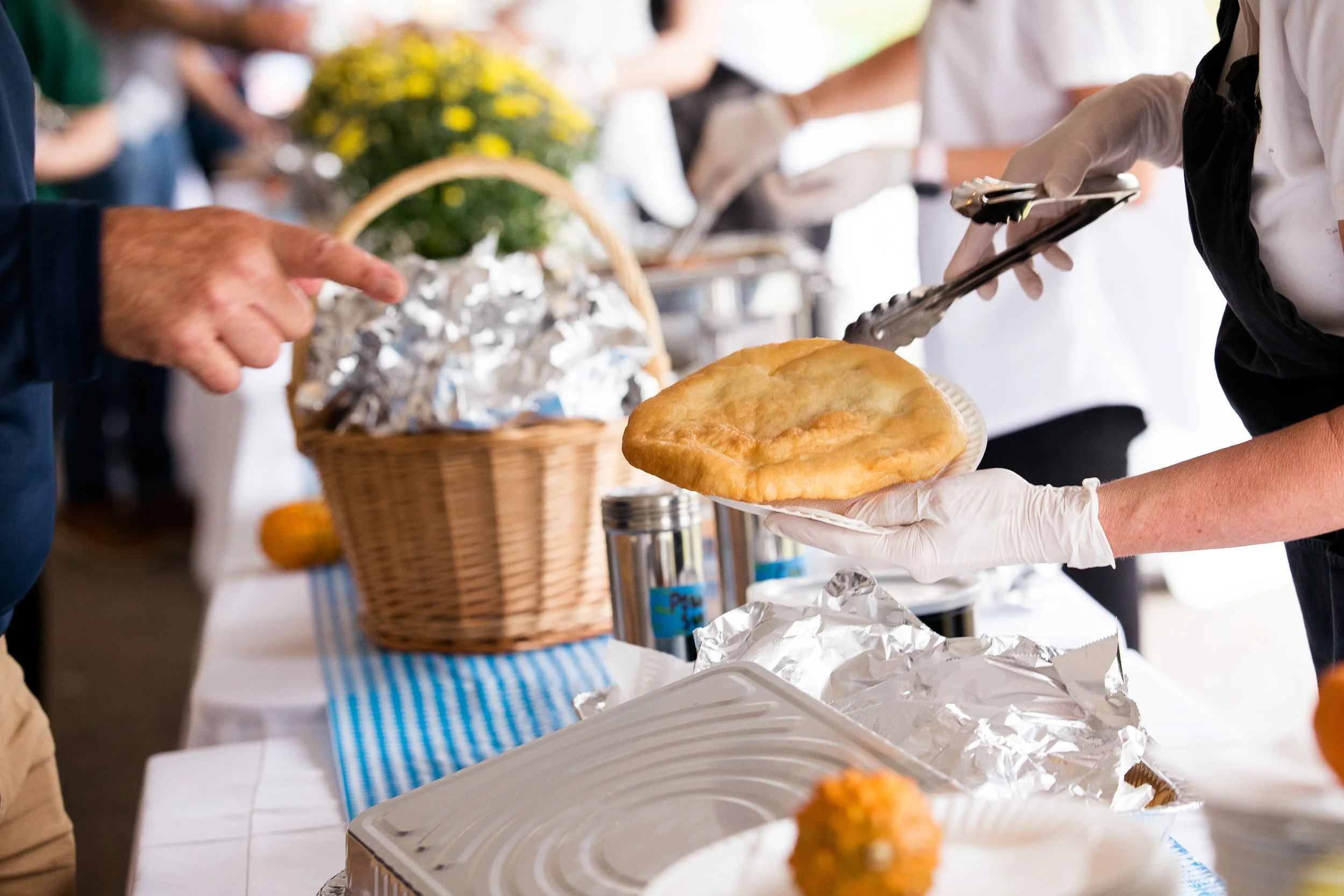 A person serving food at a buffet at an Oktoberfest event.
