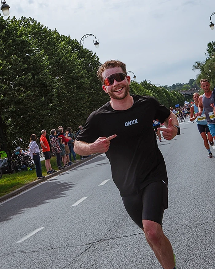 Louis Gronemberger, kiné et sportif, en train de courir les 20km de Bruxelles 2026, avec un t-shirt du running club Onyx.