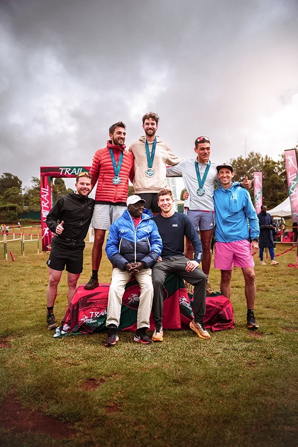 Groupe de traileurs posant avec leurs médailles après une course d'endurance, l'Iten Moutain Trail.