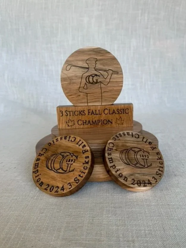 Wooden golf trophy with a silhouette of a golfer at the top, a rectangular plaque in the middle reading '3 Sticks Fall Classic Champion,' and two circular medallions at the bottom engraved with a golf club, a golf ball, and the year 2024.