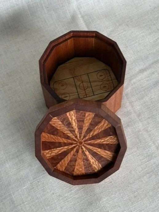 Wooden octagonal container with a hockey rink diagram inside and a matching lid with a radial pattern.