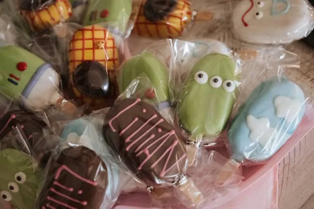 Colorful candies wrapped in clear plastic, decorated to look like insects and animals with various colors, patterns, and eye designs.