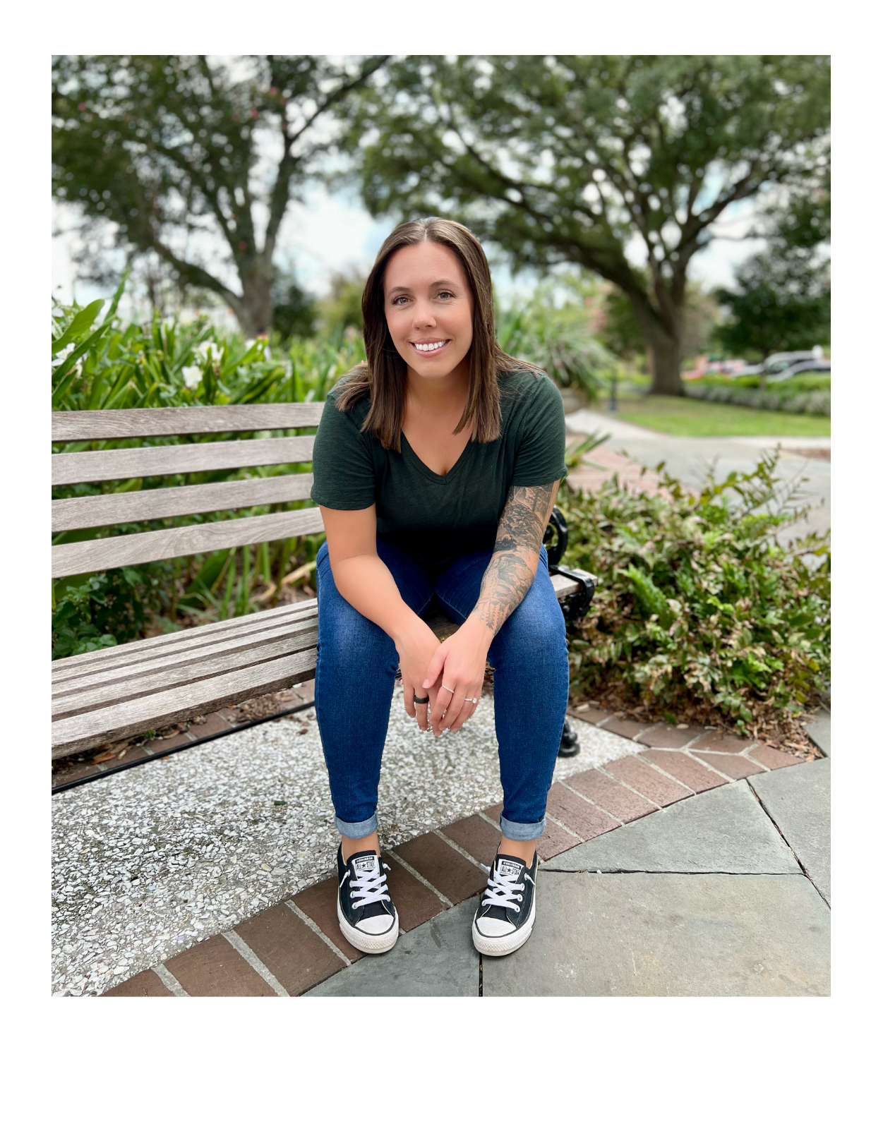 Kristin Johnson, a therapist in Summerville, SC, sitting on a park bench smiling at the camera, with greenery and trees in the background.