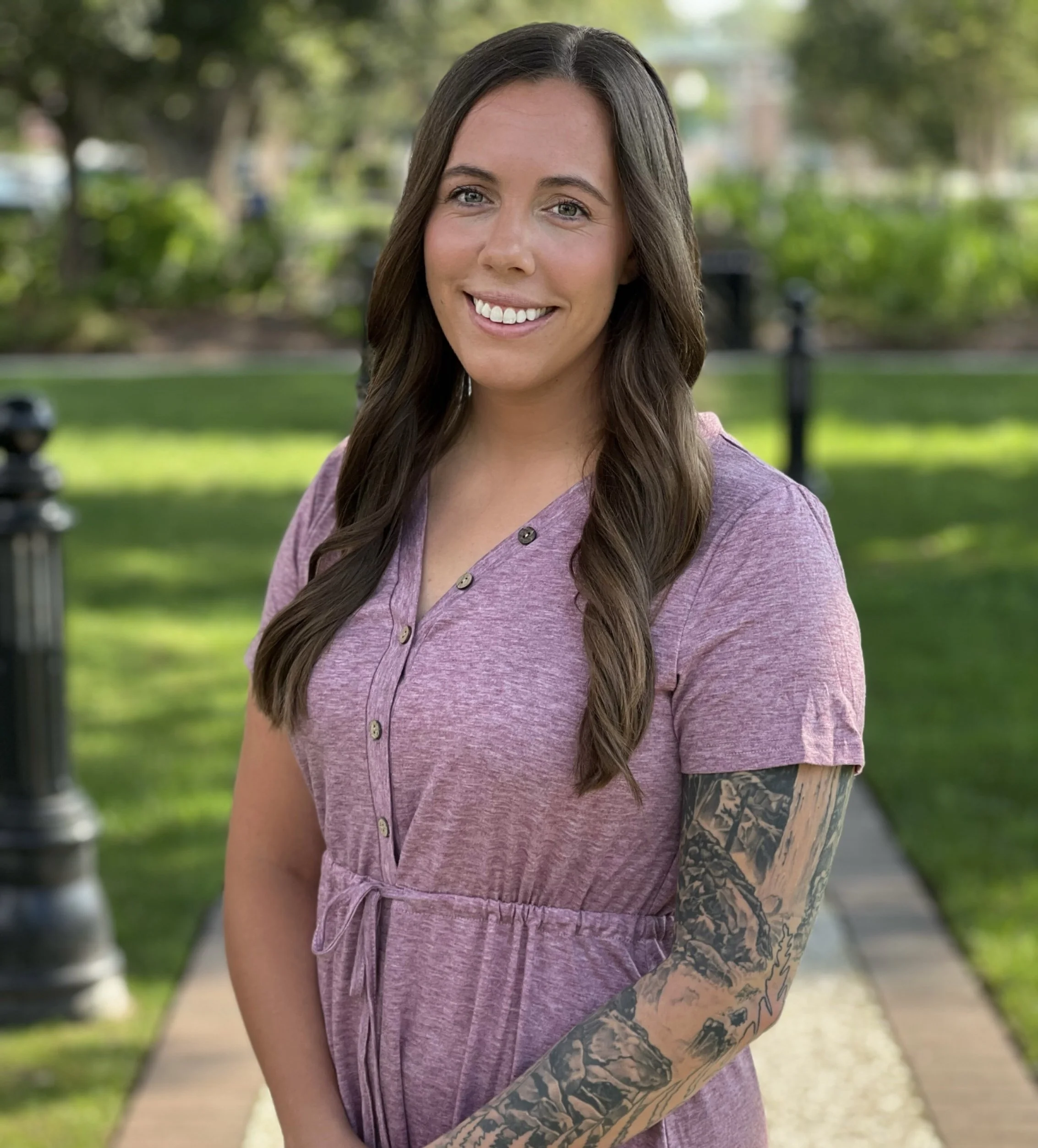 Kristin Johnson, therapist in Summerville, SC, stands outside with a green background.
