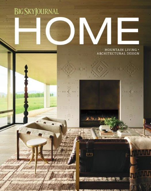 Cover of Big Sky Journal Home magazine featuring a modern living room with a large window, a fireplace, and comfortable seating, highlighting mountain living and architectural design.