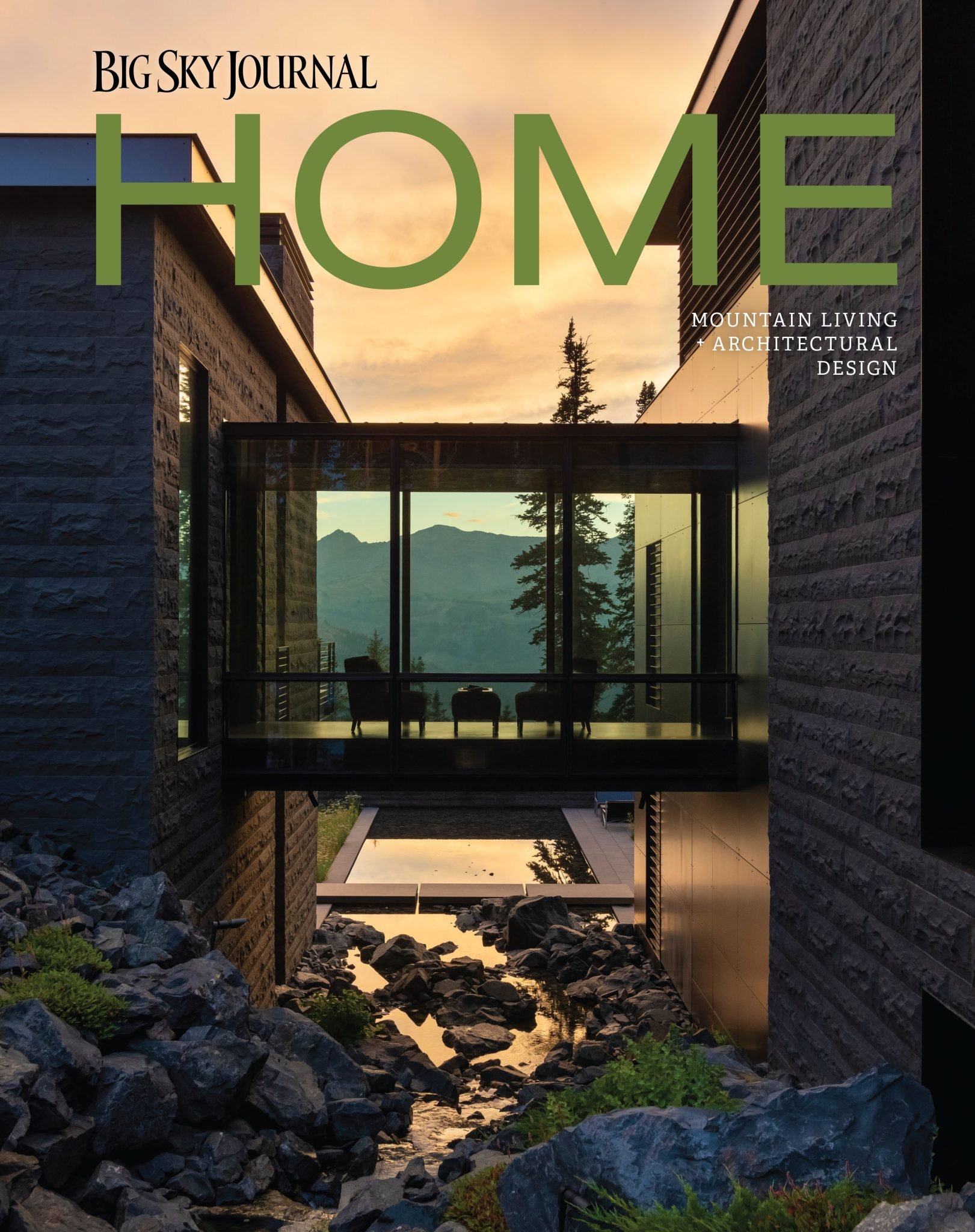 Cover of Big Sky Journal magazine featuring a modern mountain home with large glass windows and a water feature in the foreground, set against a mountainous landscape at sunset.