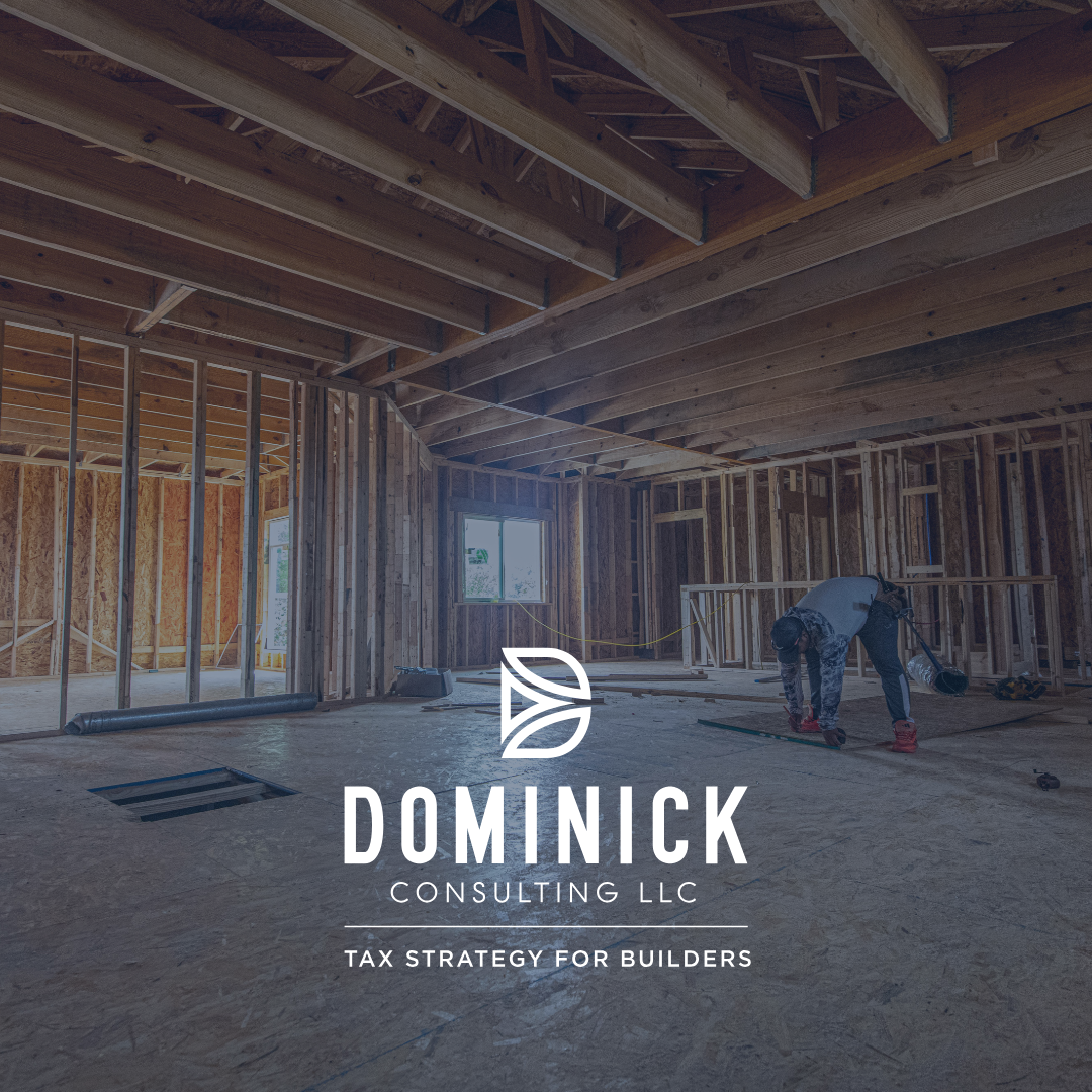 Interior view of a house under construction with unfinished wooden framing and a construction worker working on the floor.