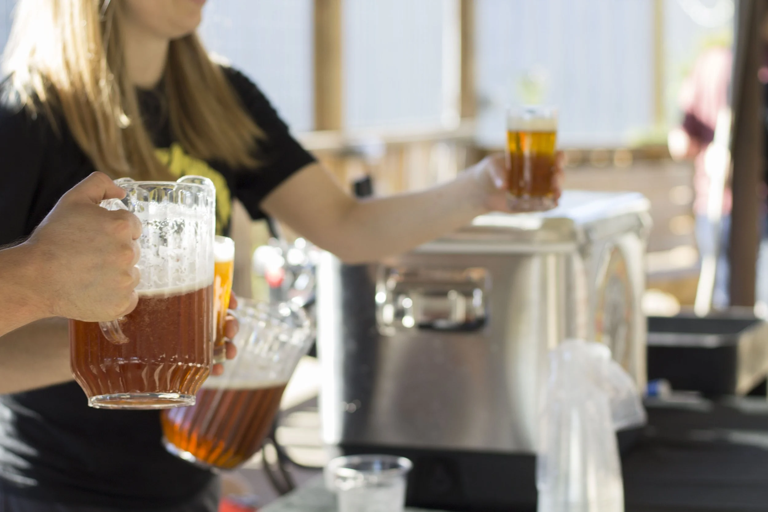 Slowpoke Studio’s website redesign for Wiseacre Brewing Company. People pouring and holding glasses of beer at an outdoor bar or event.