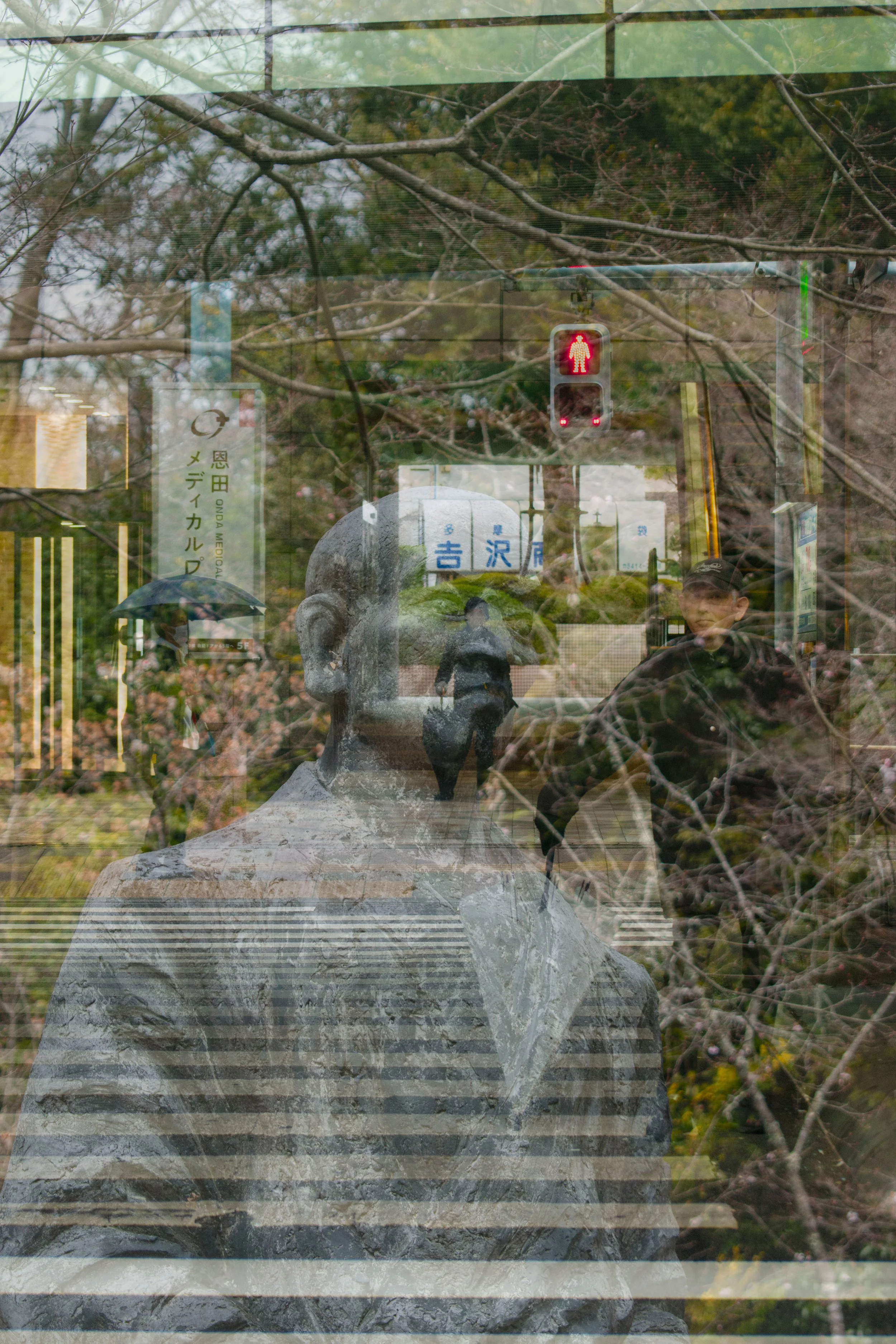 Japan double exposure film photo of stern statue face overlaid with Japanese sidewalk