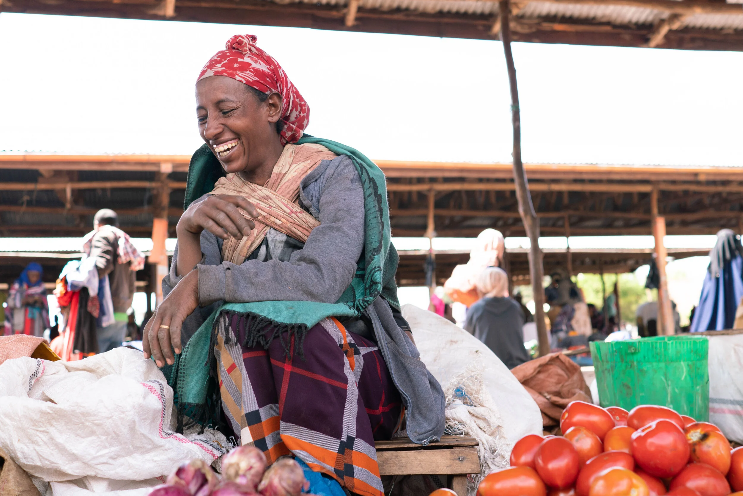 Ethiopian Mother selling produce at a stall in the market, smiling and laughing