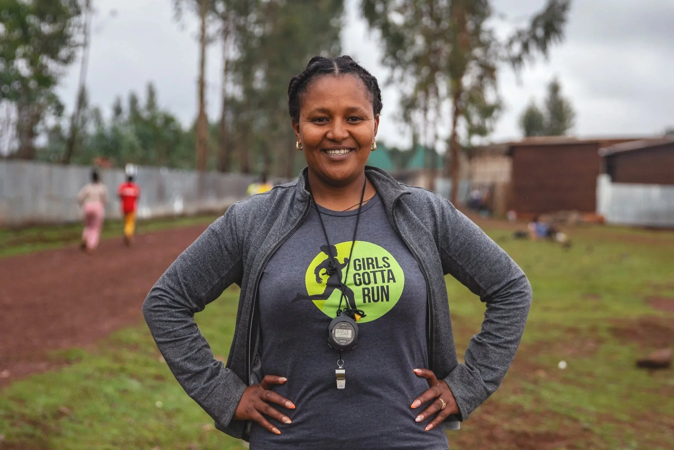 Portrait photo of Coach Fatiya smiling with hands on her hips