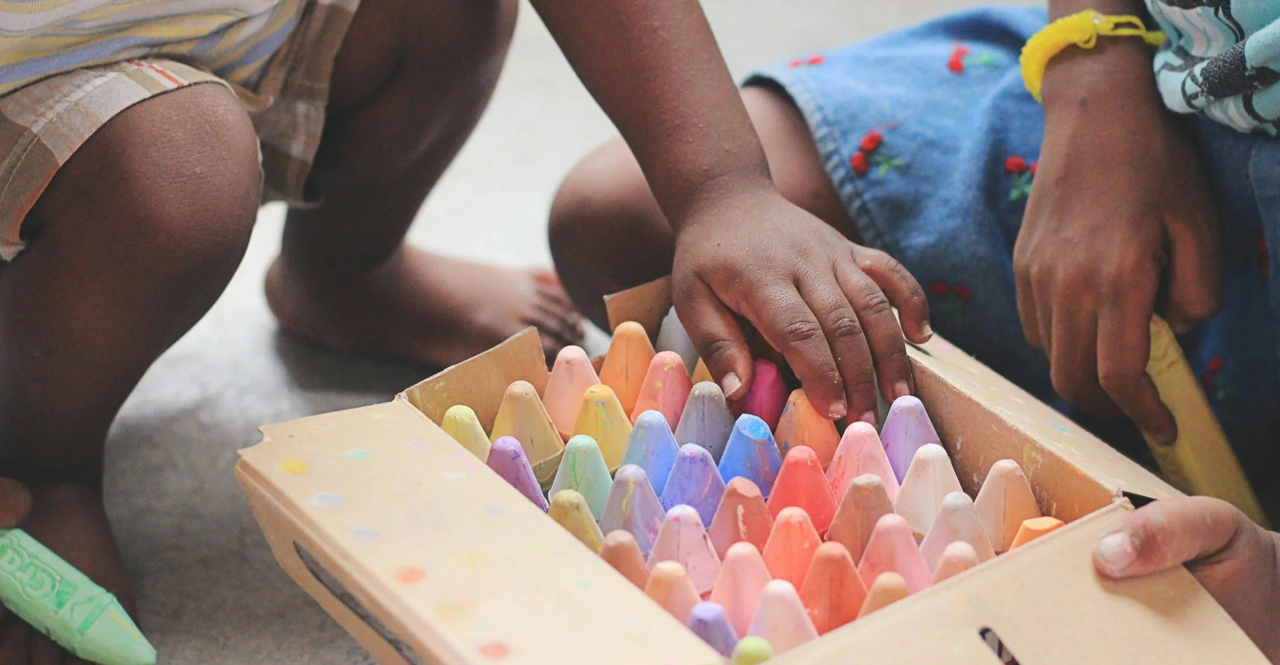 Children reaching for chalk