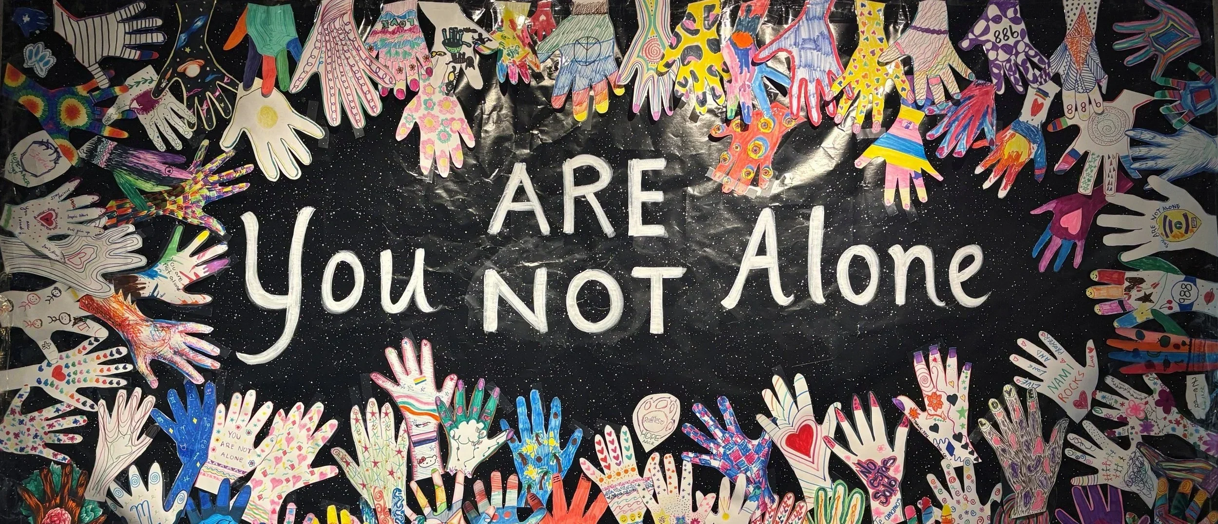 mural of hands that reads, 'you are not alone'