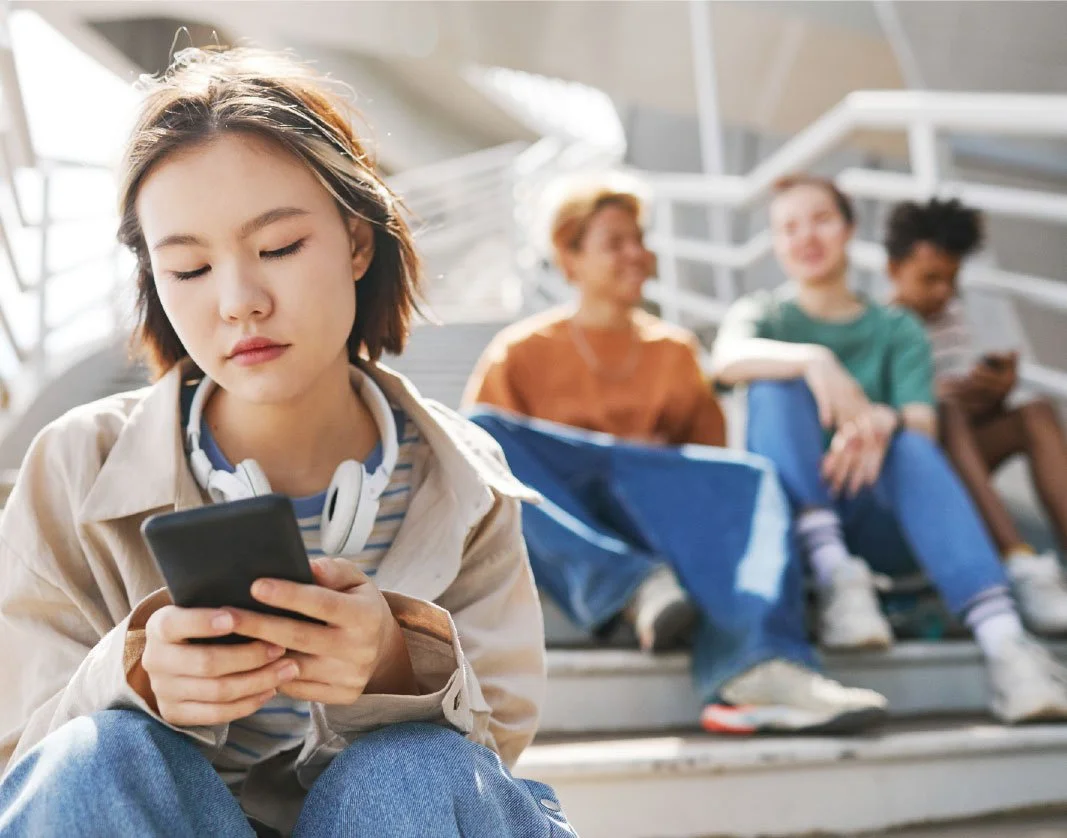 Girl texting amongst a group of people