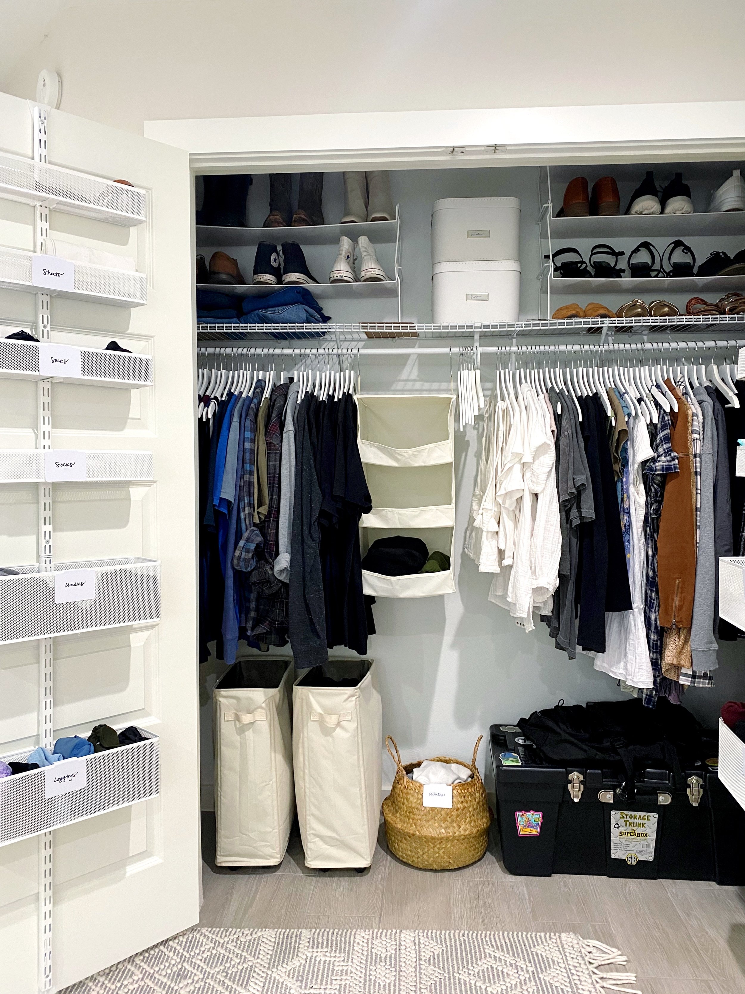 Closet with hanging clothes, shelves of shoes, storage bins, and laundry baskets.