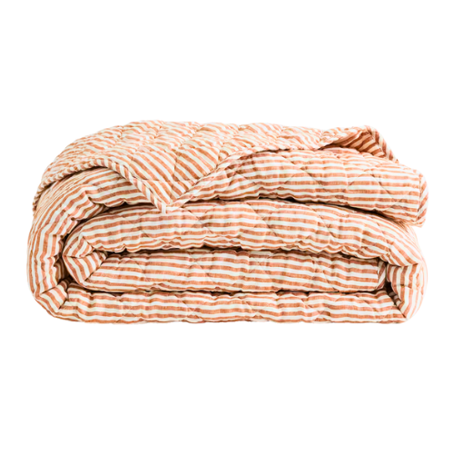 Folded striped comforter with matching pillow on a black background.