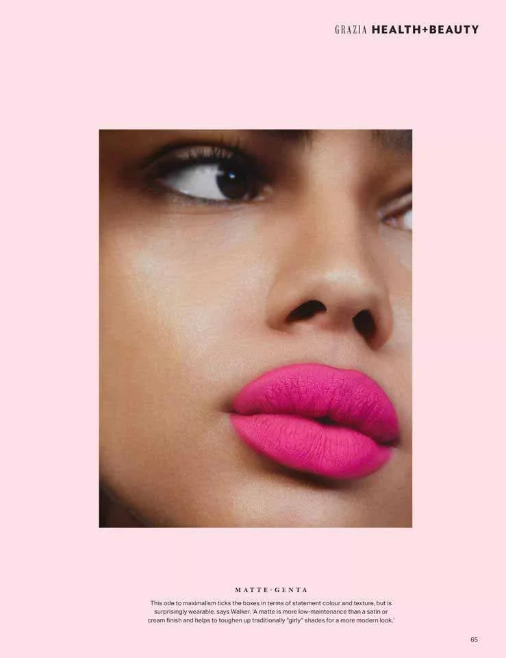 Close-up of a woman's face with matte pink lipstick, eye makeup, and smooth skin on a pink background, with text referencing Grazia health and beauty.
