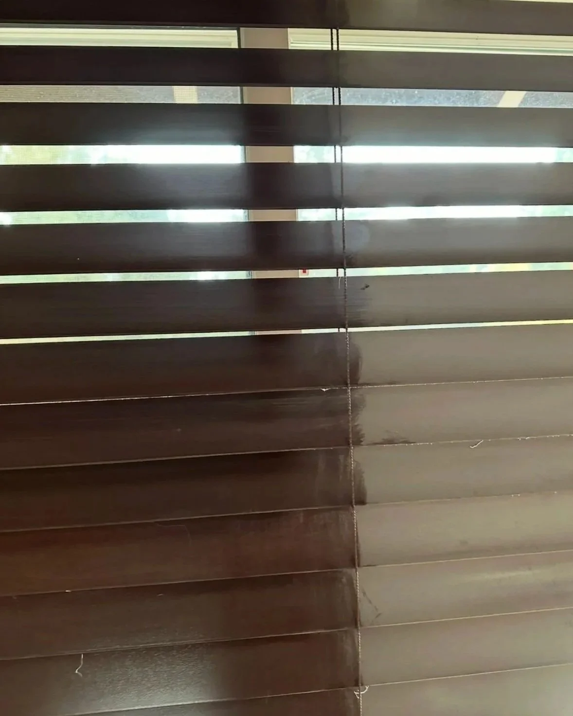 View through window blinds, some light coming through the gaps.