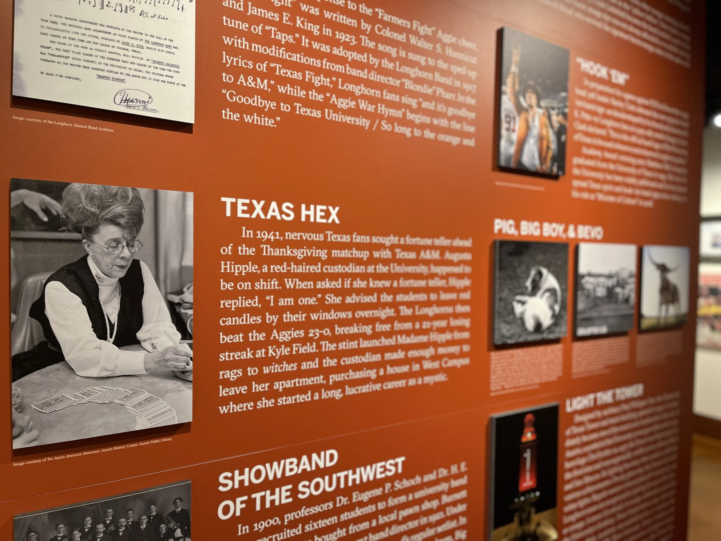Black and white photograph of a woman with glasses, seated at a table, playing cards.