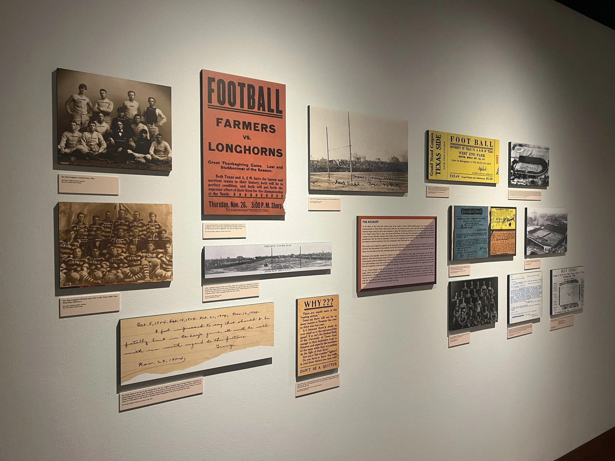 A museum wall display featuring vintage photographs, gameday tickets, handwritten notes, and info panels about football history.