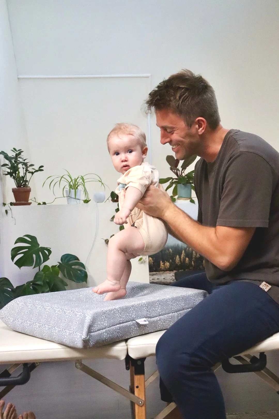 Dr. Joe Thompson performing a gentle chiropractic adjustment on an infant at Rhythm Health & Performance in Santa Cruz