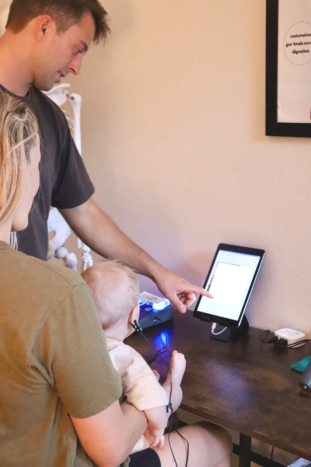 Dr. Joe Thompson using INSiGHT scanning technology to assess nervous system function at Rhythm Health & Performance in Santa Cruz