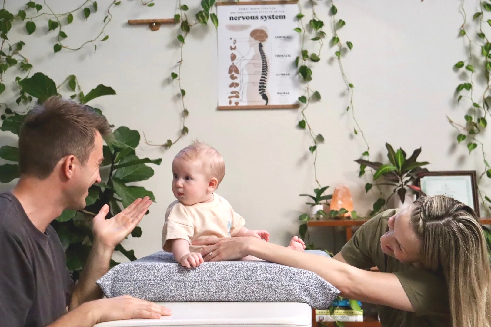 Dr. Joe Thompson interacting with an infant during a chiropractic visit at Rhythm Health & Performance in Santa Cruz