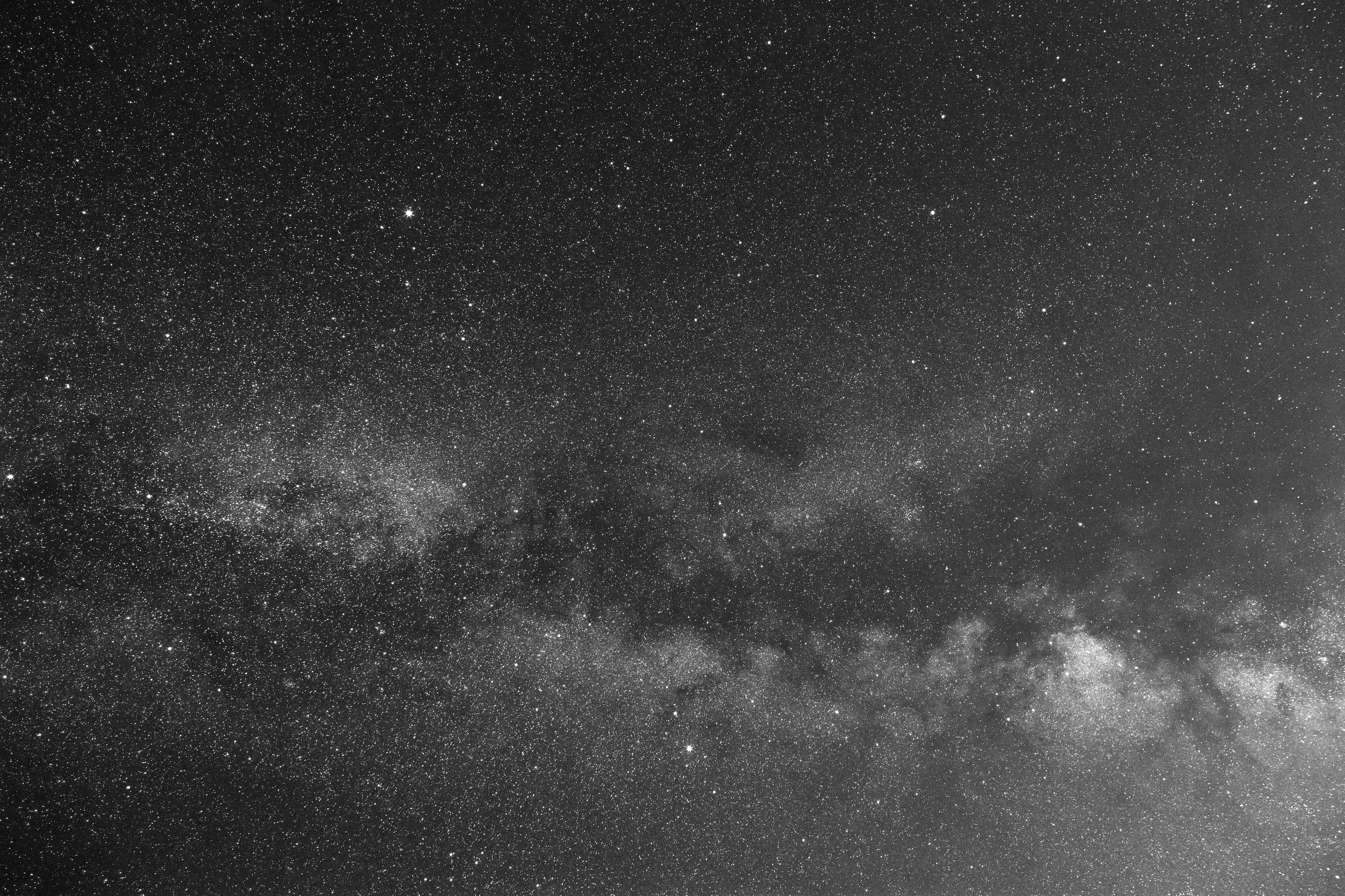 A panoramic view of the star-filled night sky with countless stars and a faint Milky Way galaxy.