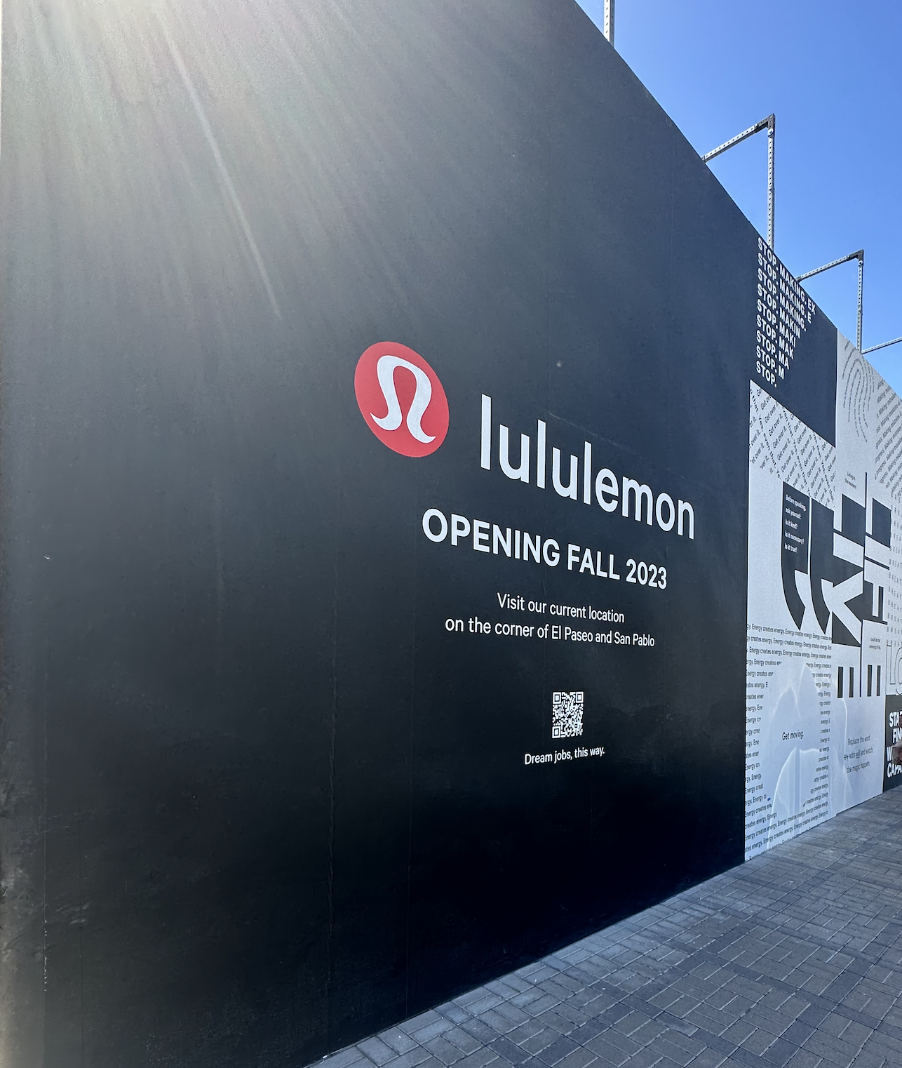 Billboard announcing LuluLemon store opening in fall 2023 at the corner of El Paseo and San Pablo, with the LuluLemon logo, QR code, and text about current location and job opportunities.
