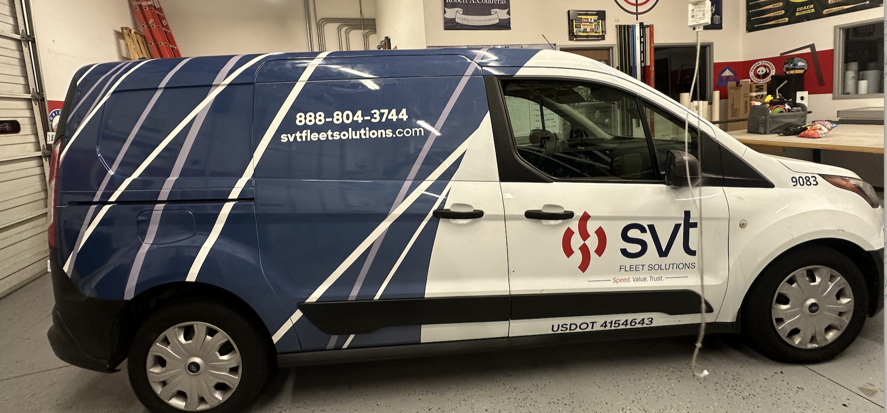 A white and blue SVT Fleet Solutions service van parked in a garage.
