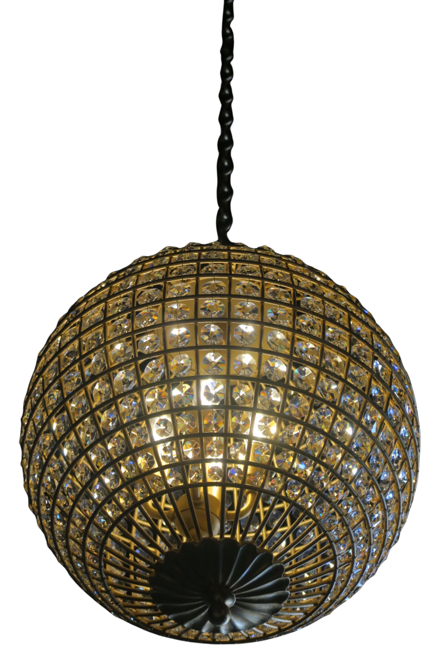 A spherical chandelier decorated with numerous crystals, hanging from a decorative black fixture against a black background.