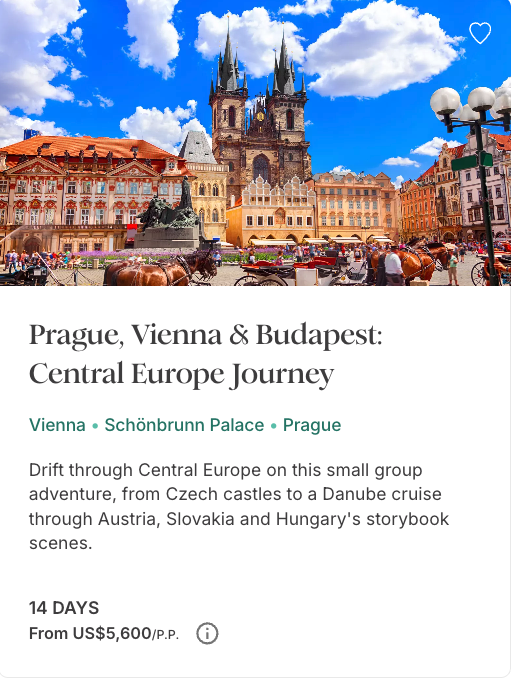 Historic Old Town Square in Prague with Gothic church towers, colorful buildings and horse-drawn carriages.