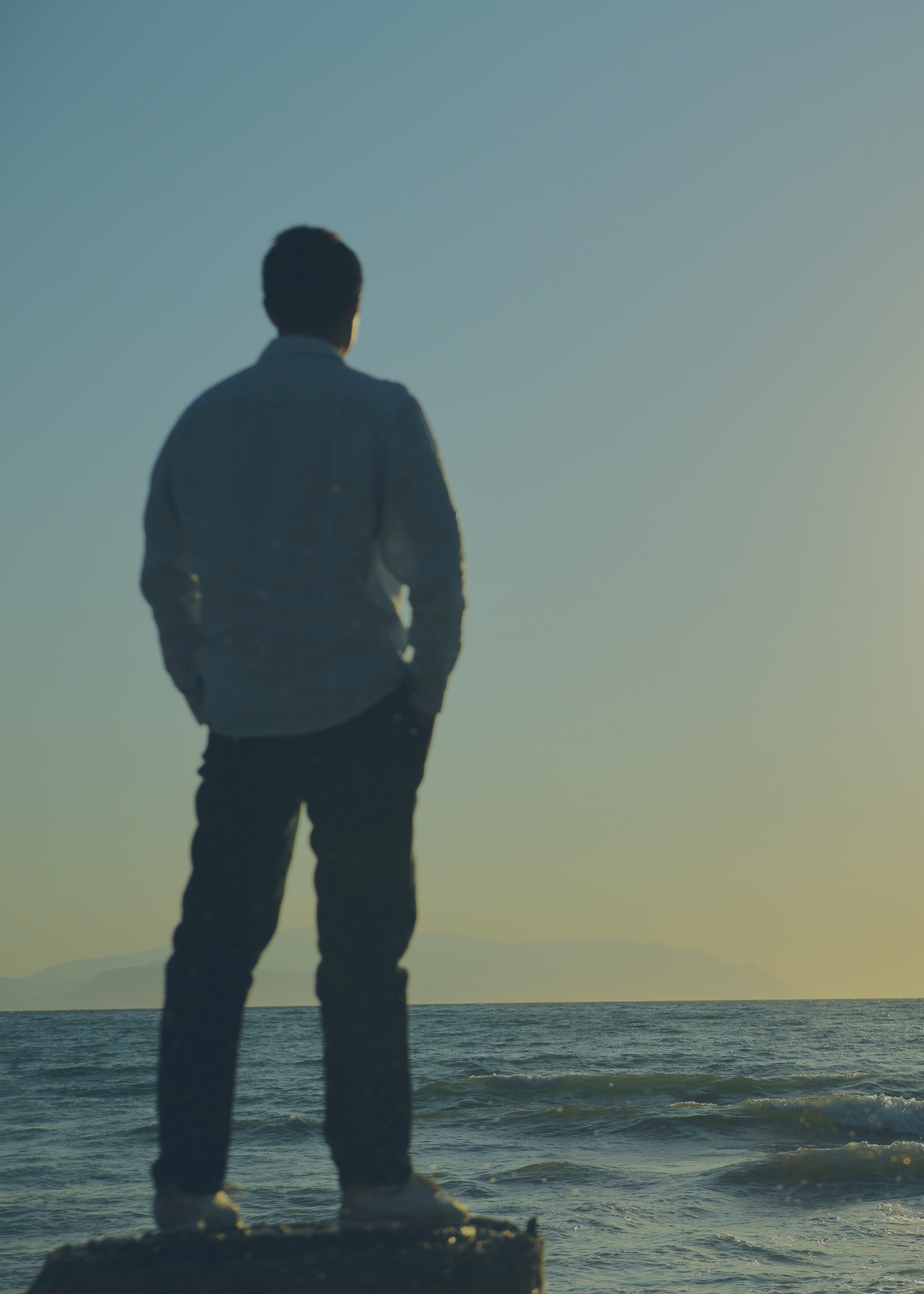 A man staring at the beach in a reflective moment - Dr. Aamir Khan Psychiatry