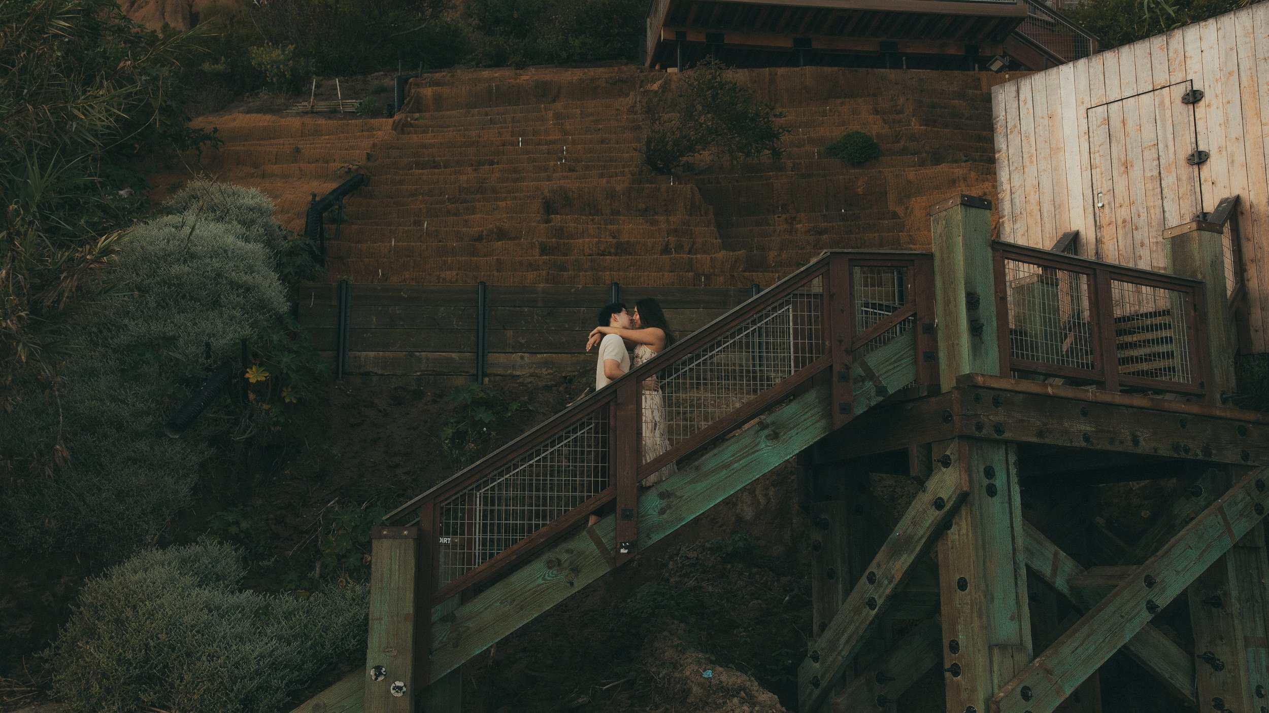 Oahu elopement couple kissing on outdoor staircase at sunset