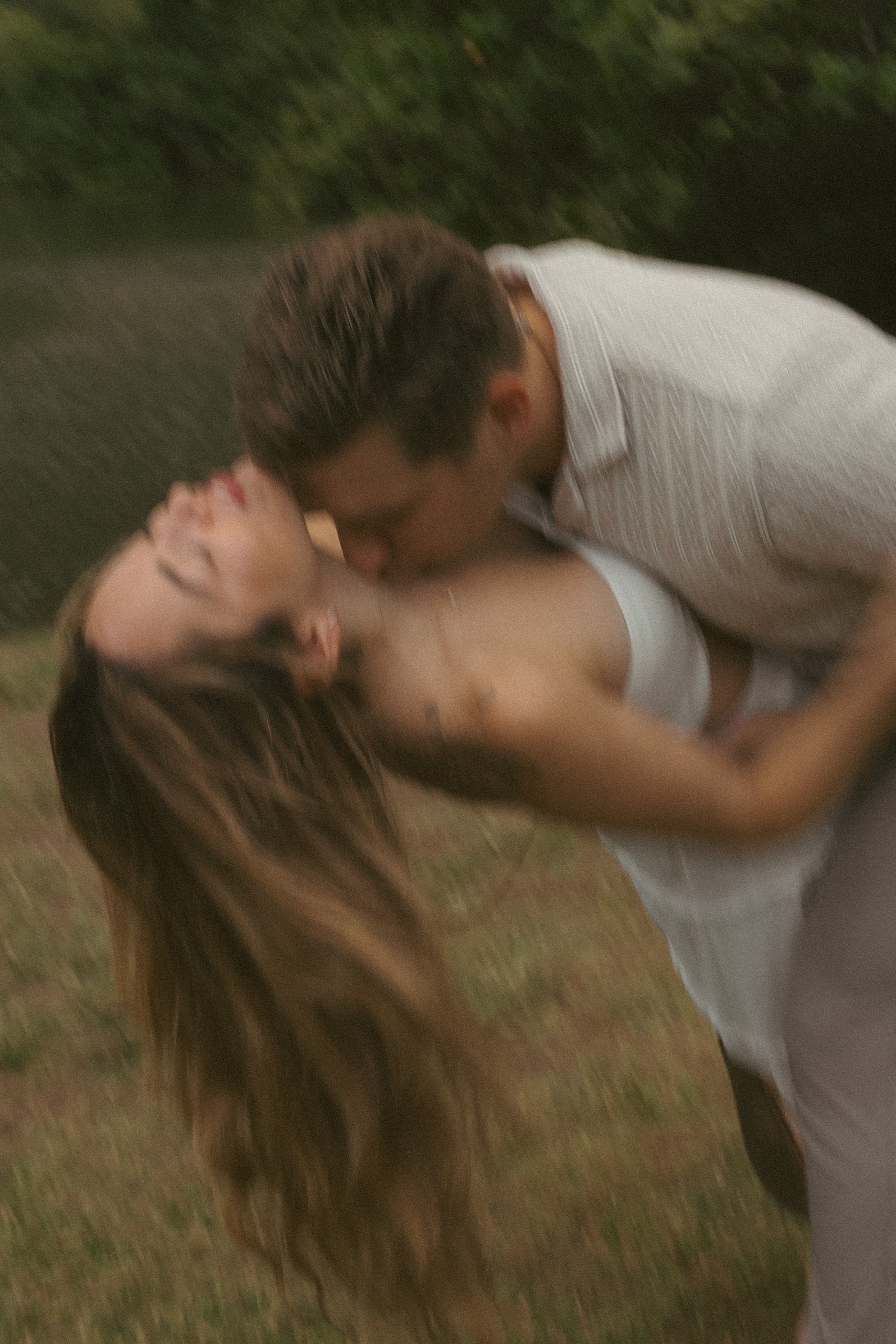 Motion blur photo of couple dipping and kissing outdoors on Oahu's North Shore, cinematic film-inspired style by Maggie T Photography