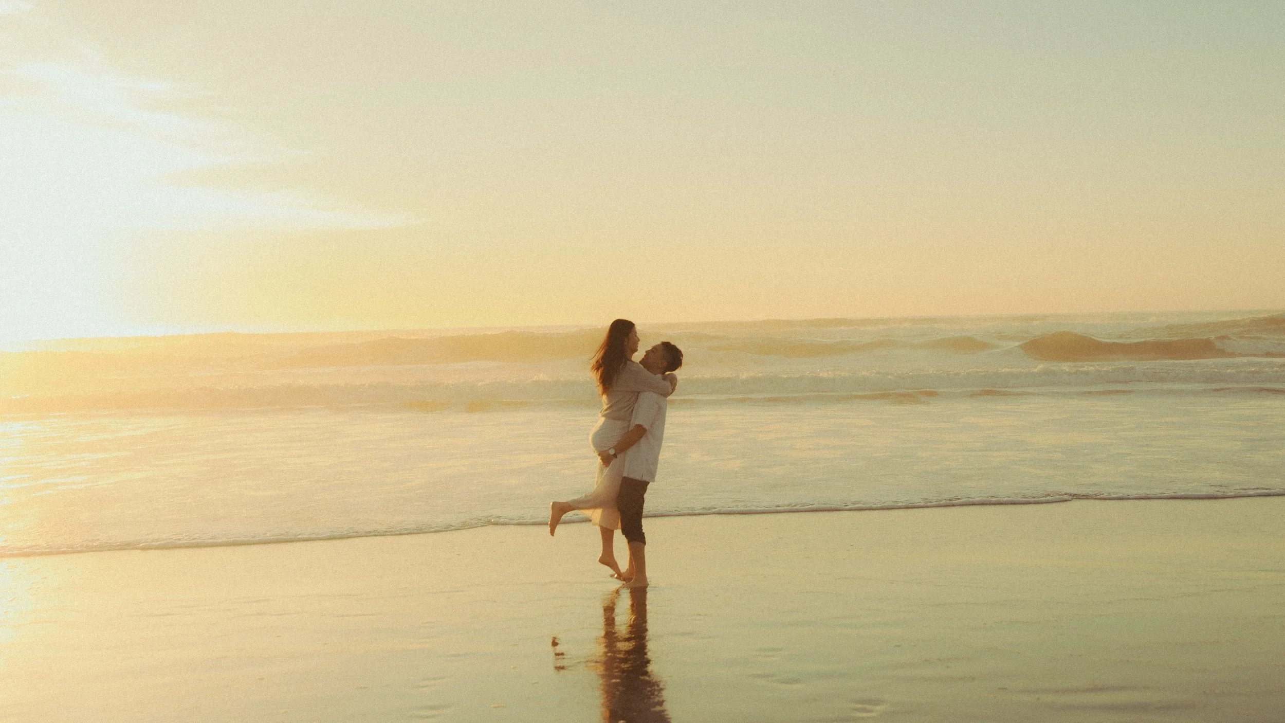 Oahu playful couples photography in ocean at sunset