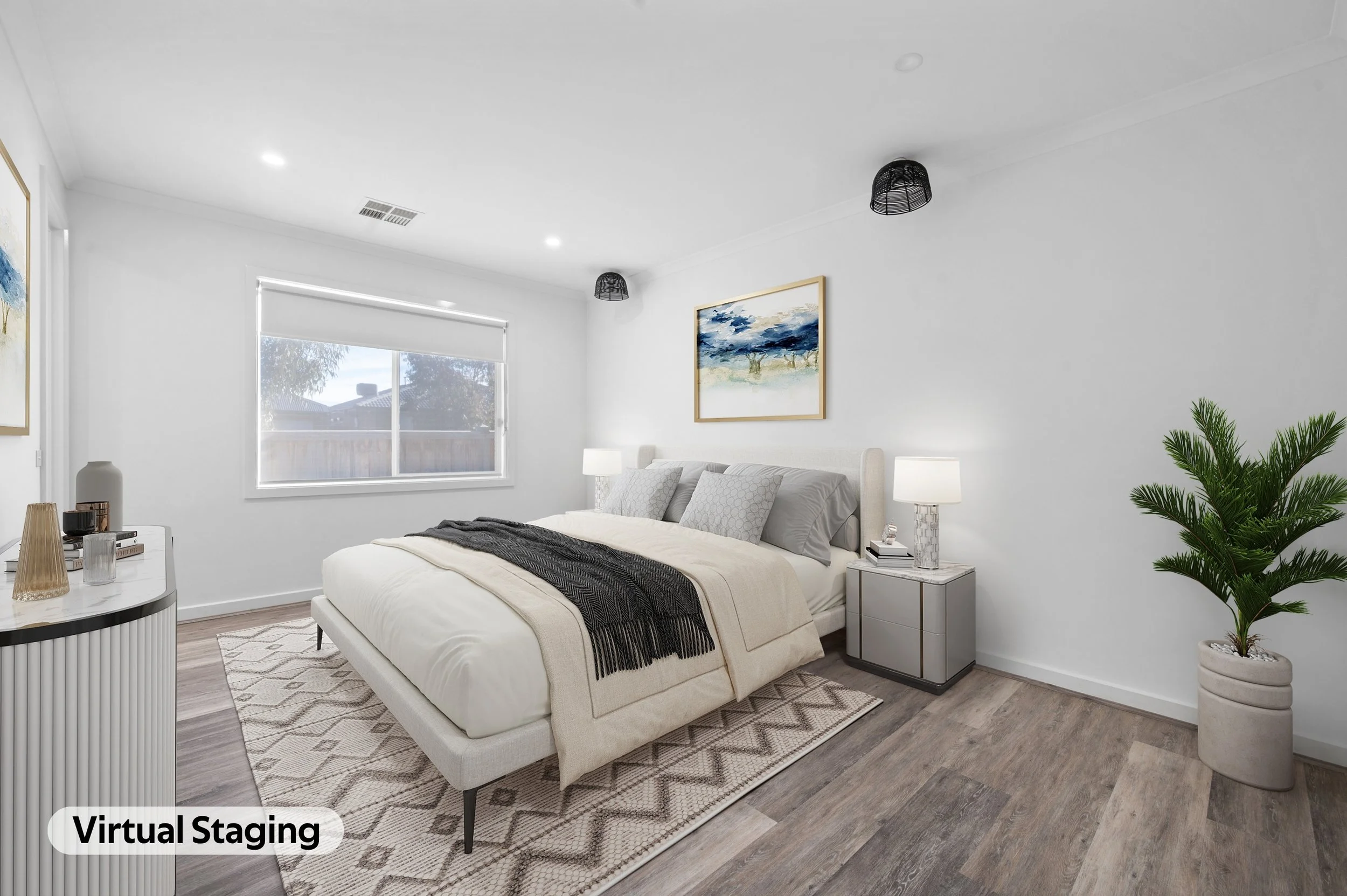 A modern bedroom with a white bed, dark blanket, and decorative pillows. There are nightstands with lamps, a potted plant, and artwork on the walls. A window with a blind lets natural light in.