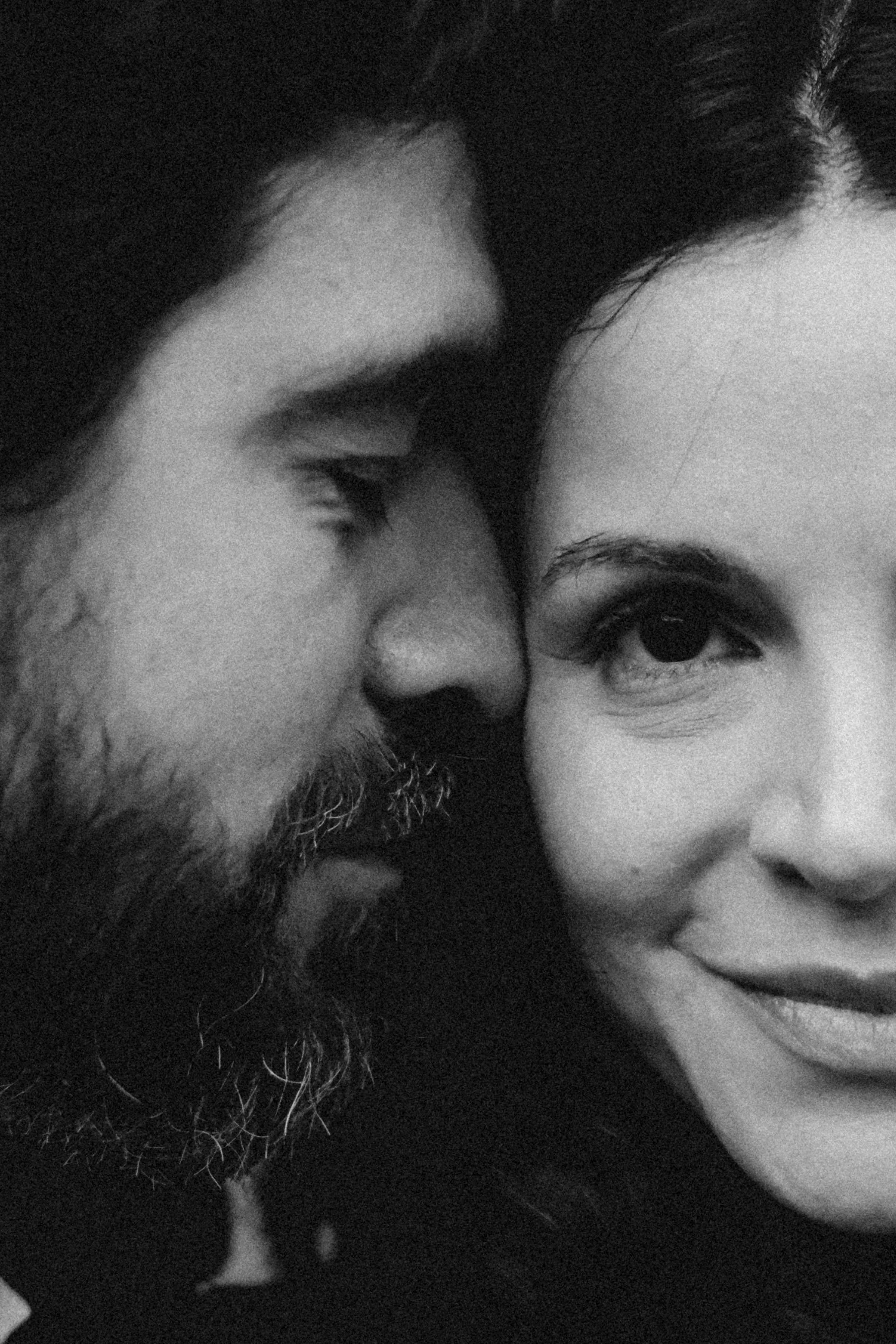 Primer plano de un hombre con barba y una mujer, ambos con expresión amable, en una fotografía en blanco y negro.