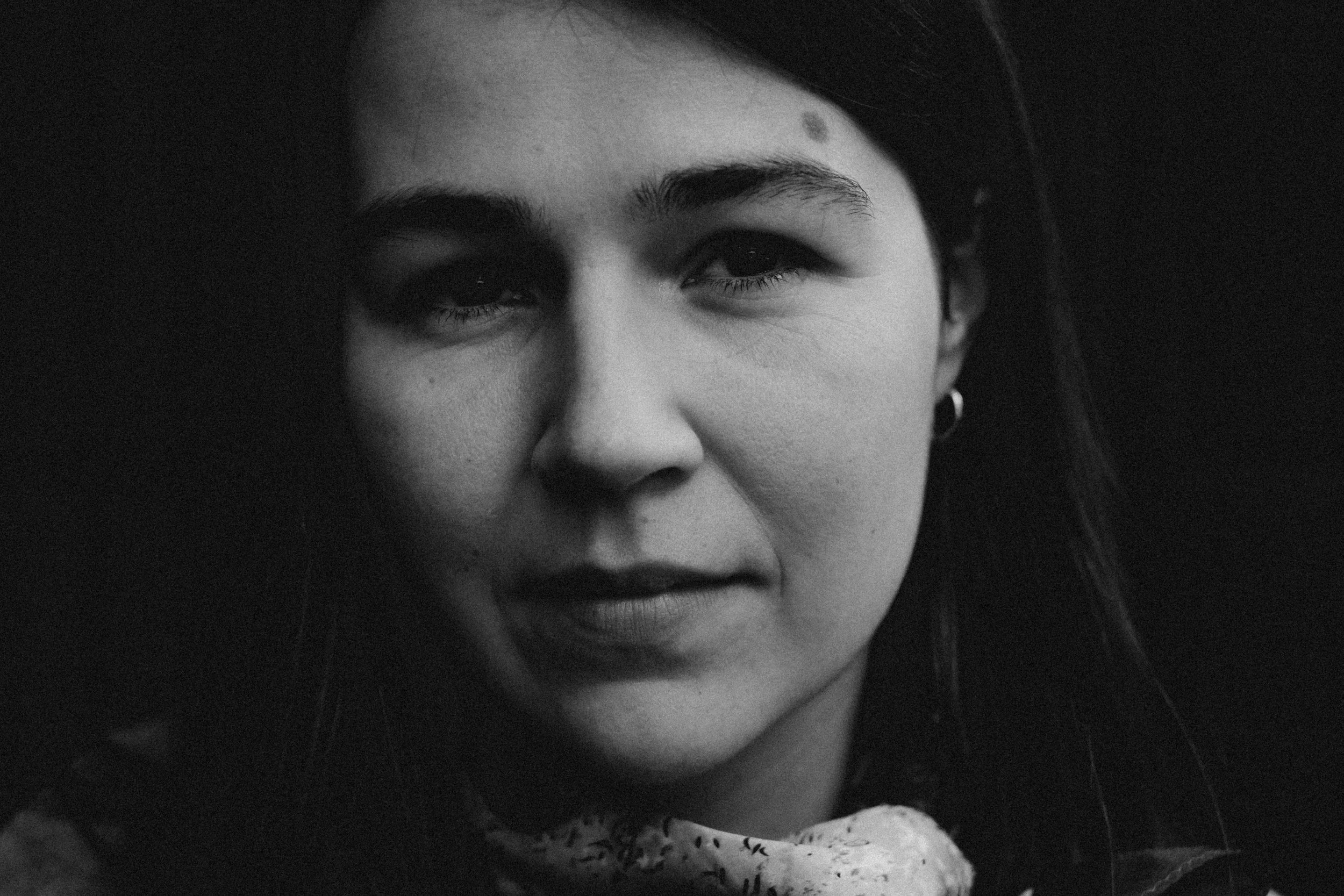 Retrato en blanco y negro de una mujer con cabello oscuro y piel clara, con una expresión neutral o ligeramente sonriendo.