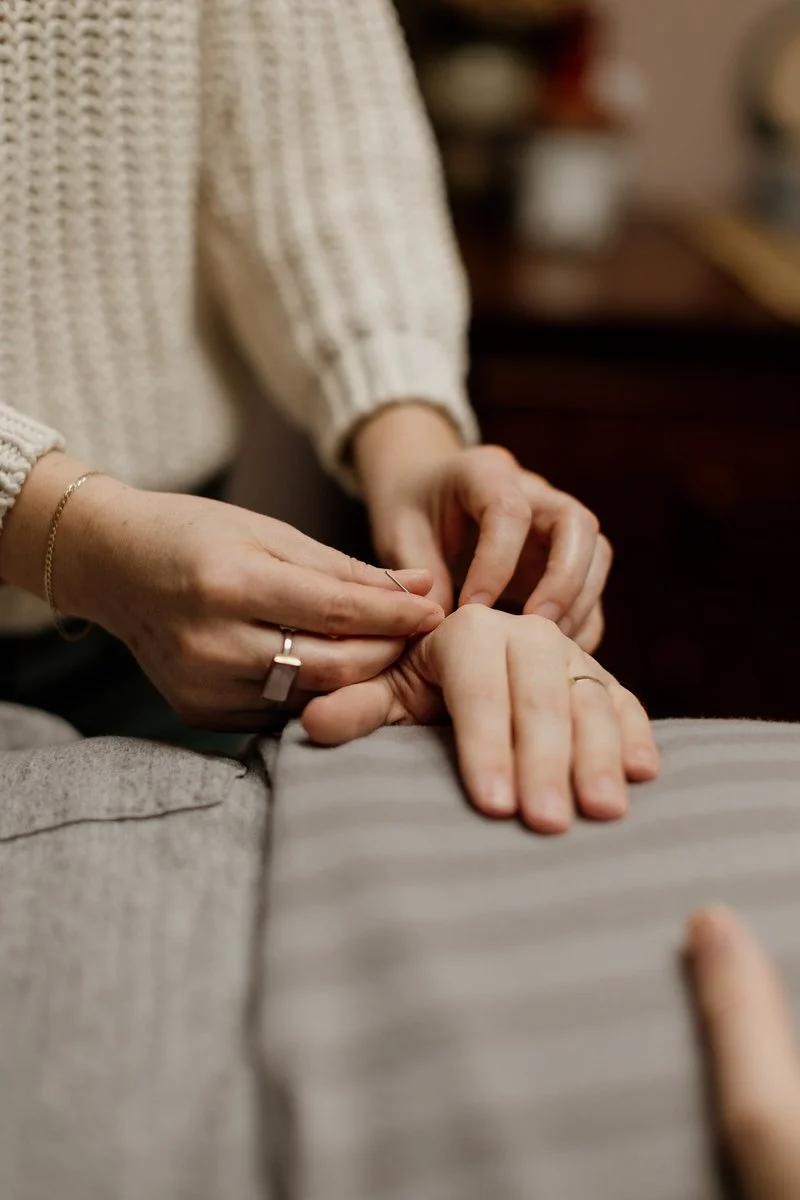 Acupuncturist Kelly Baucum applying gentle acupuncture to a patient's hand. Kelly is trained in the Japanese style of acupuncture, a gentle and refined practice using very small gauges of needles inserted to a very shallow depth.