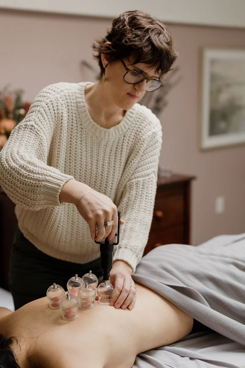 Acupuncturist Kelly Baucum applying gentle cupping to a patient's back.