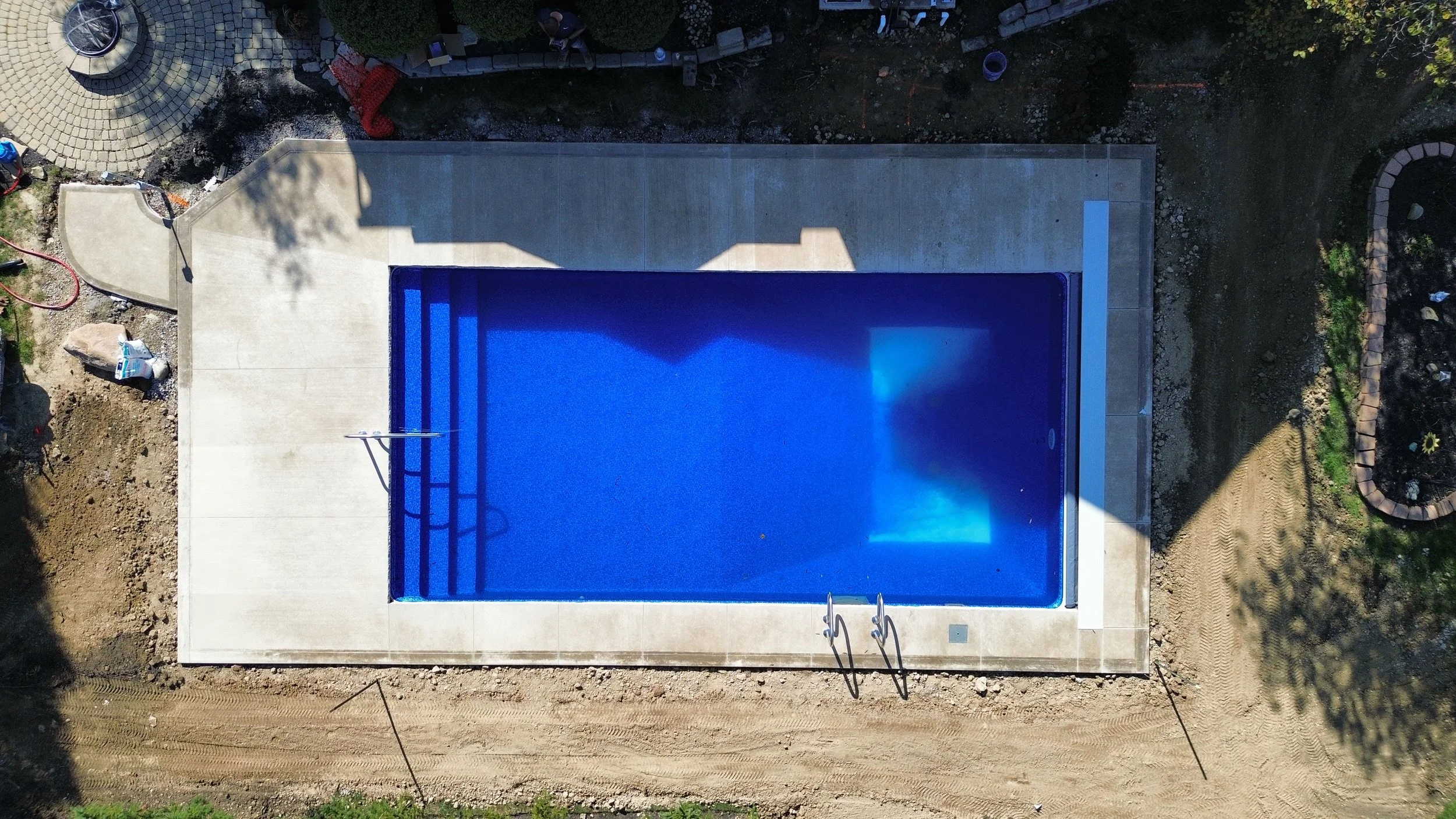 High-quality vinyl pool liner replacement service featuring a vibrant blue textured liner being installed on-site by professional contractors.