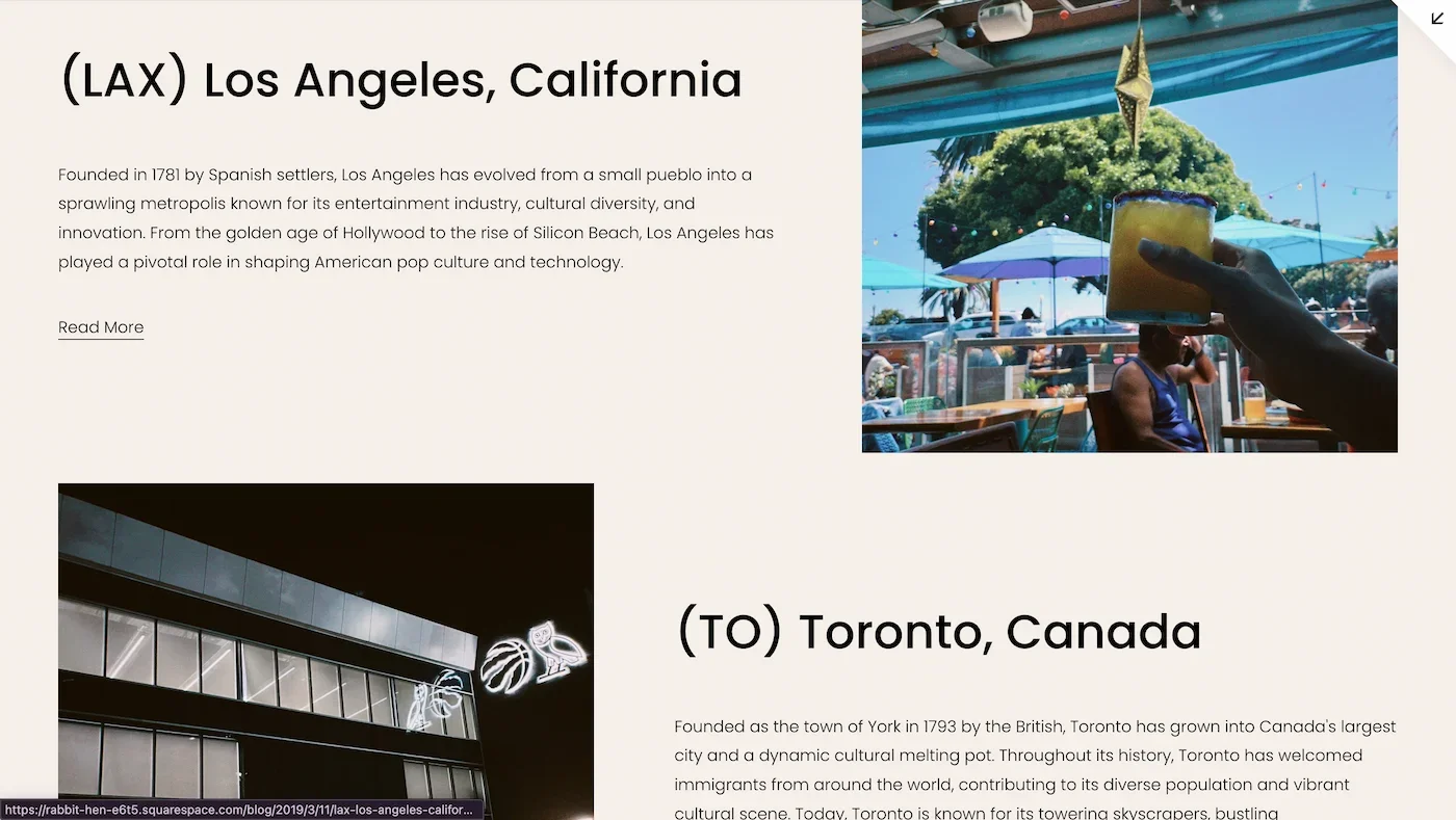 A person holding a glass of yellow-orange beverage outdoors at a restaurant with blue umbrellas, palm trees, and string lights in the background.